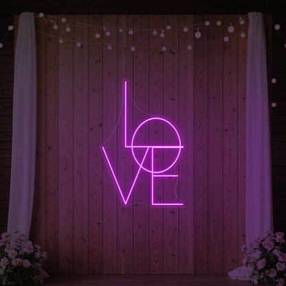 Photo of the 'LOVE' neon sign glowing in deep pink against a styled interior wall.