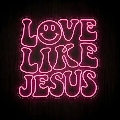 Love Like Jesus LED neon sign featuring bold retro pink lettering with a smiling face design on a precision-cut clear acrylic backing for Christian wall decor.