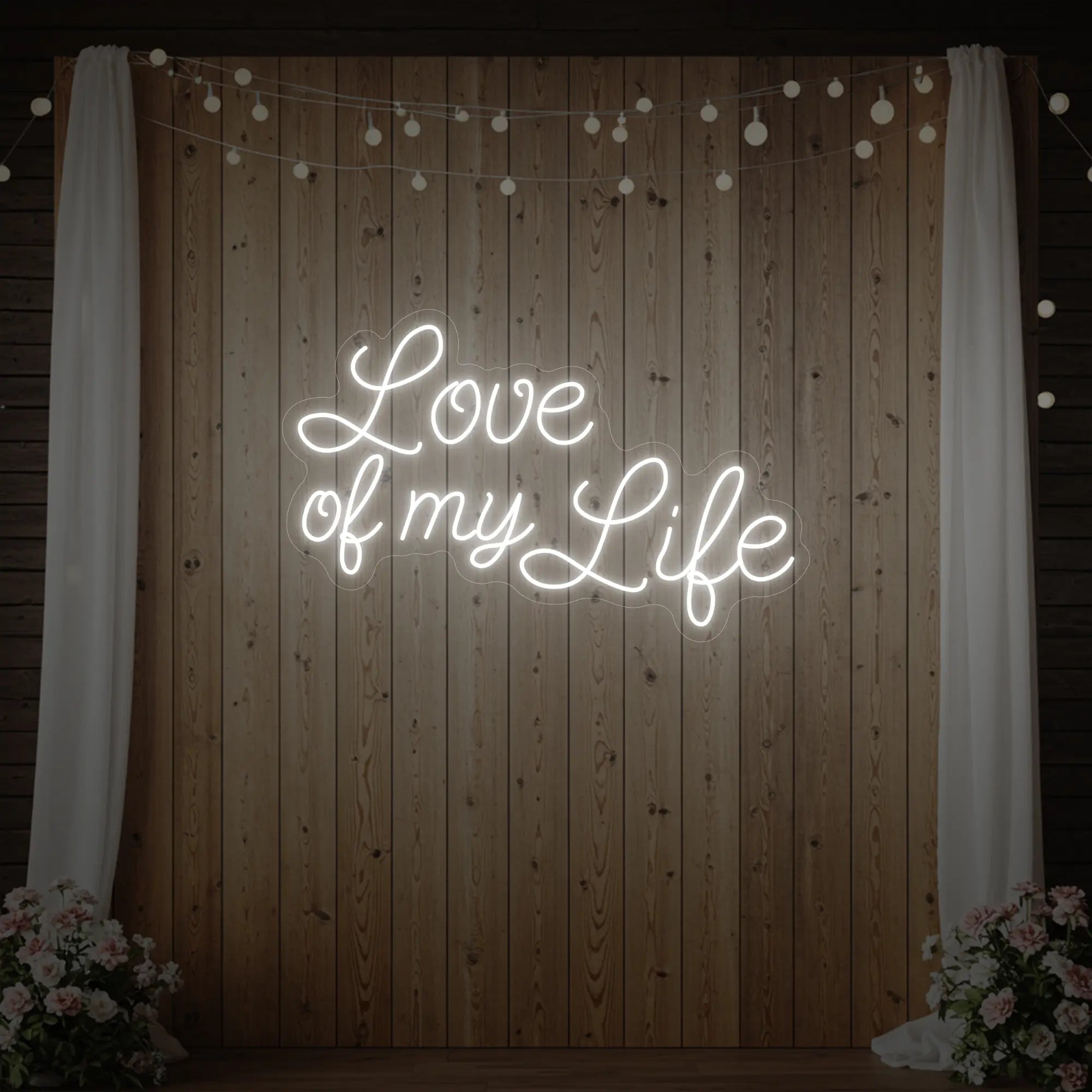 Photo of the 'Love of My Life' neon sign glowing in cool white against a styled interior wall.
