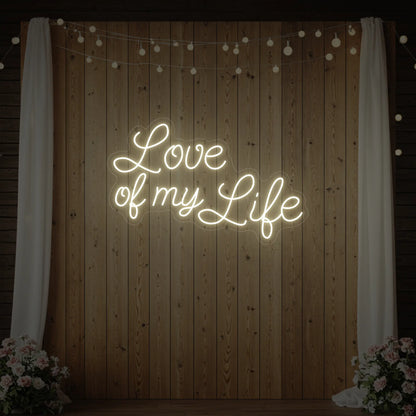 Photo of the 'Love of My Life' neon sign glowing in warm white against a styled interior wall.