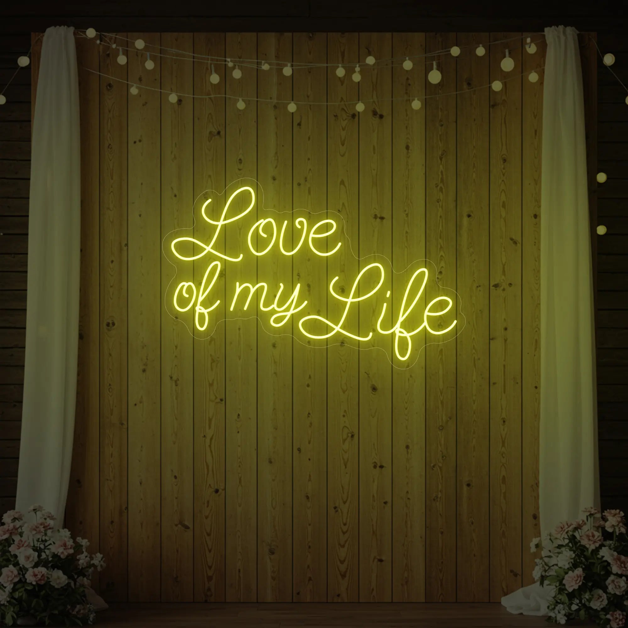 Photo of the 'Love of My Life' neon sign glowing in lemon yellow against a styled interior wall.