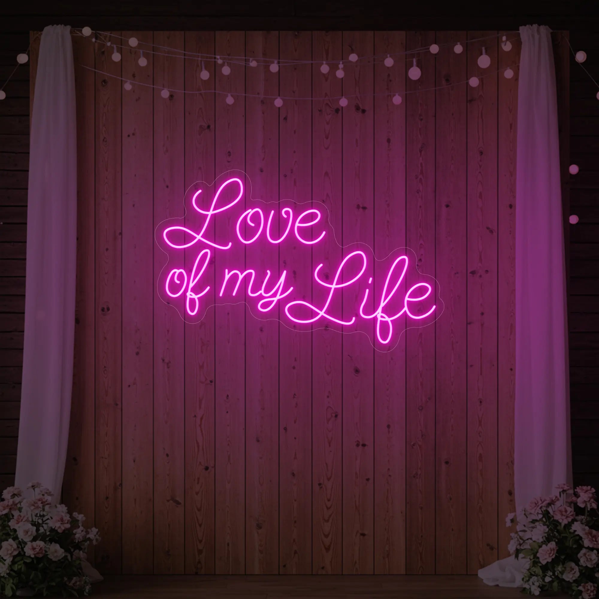Photo of the 'Love of My Life' neon sign glowing in light pink against a styled interior wall.