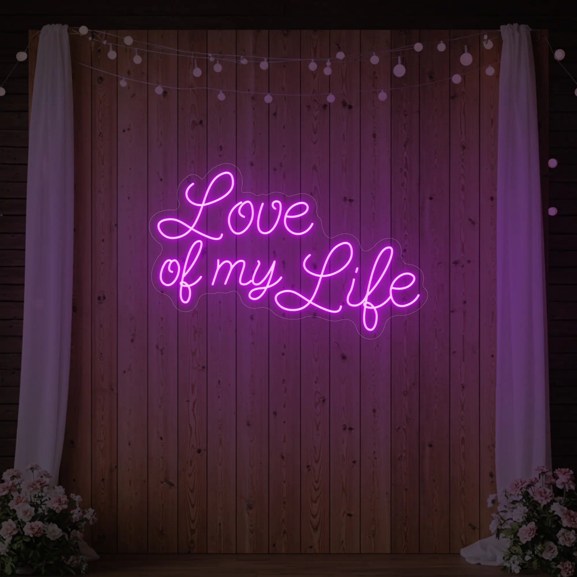 Photo of the 'Love of My Life' neon sign glowing in deep pink against a styled interior wall.