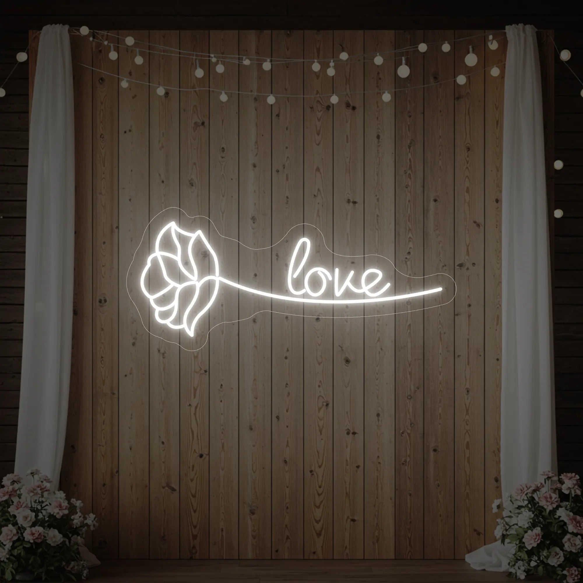 Photo of the 'Just Love Rose' neon sign glowing in cool white against a styled interior wall.