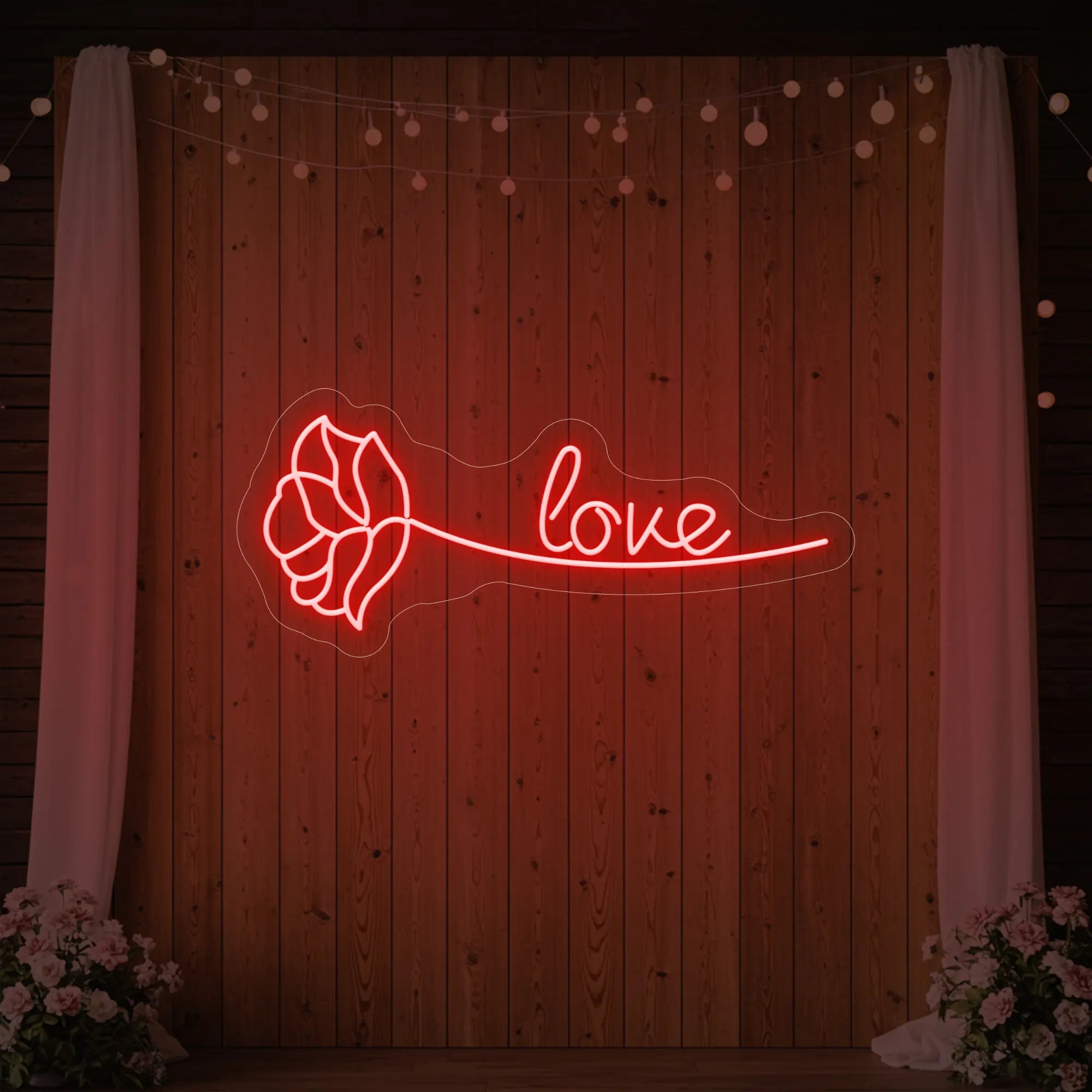 Photo of the 'Just Love Rose' neon sign glowing in red against a styled interior wall.