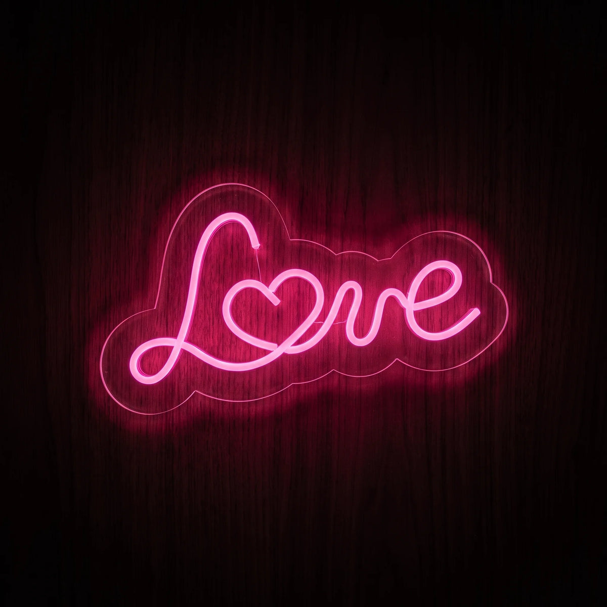 Love Script LED Neon Sign featuring pink cursive lettering with a heart detail on clear acrylic backing.