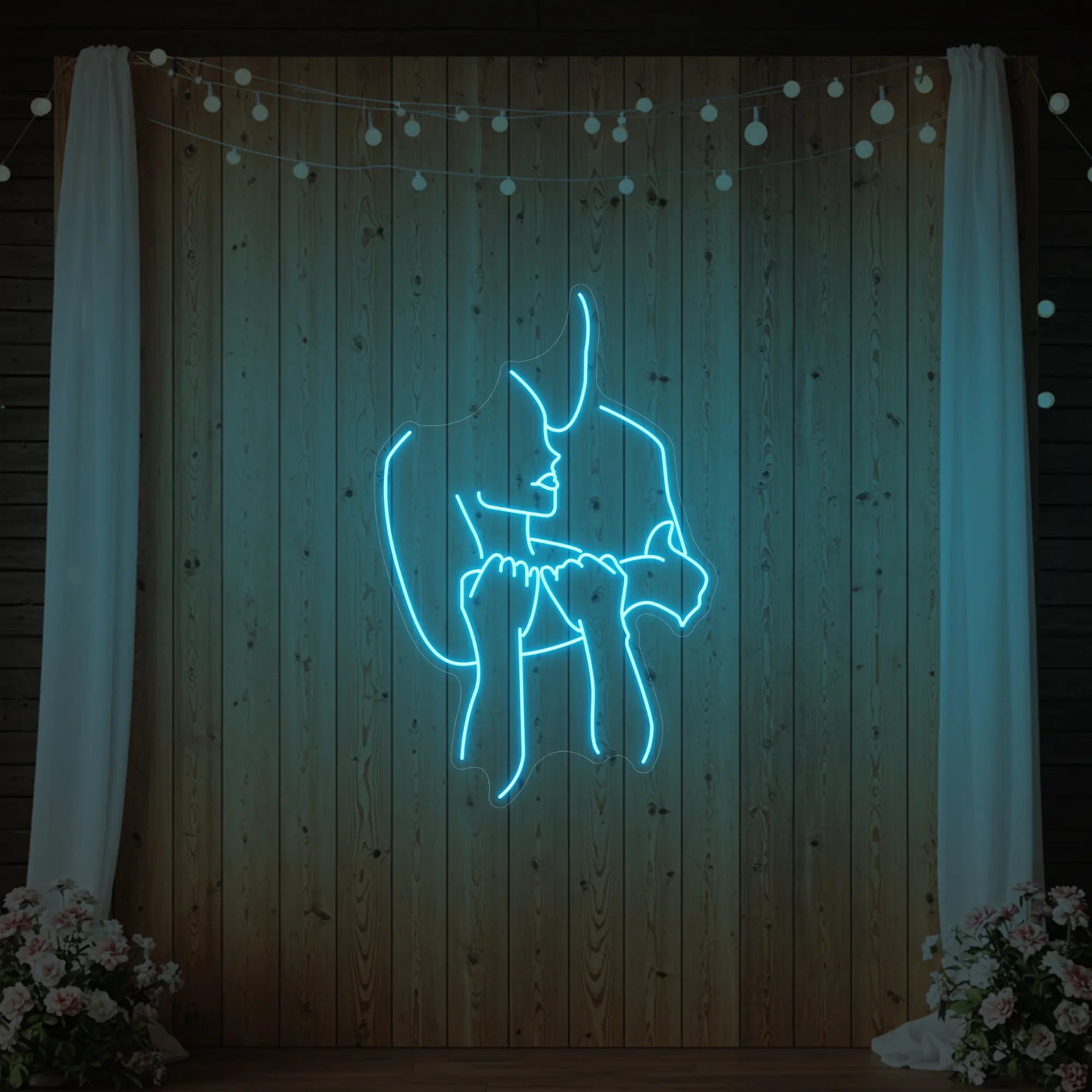 Photo of the 'Lovers Holding Each Other' neon sign glowing in ice blue against a styled interior wall.
