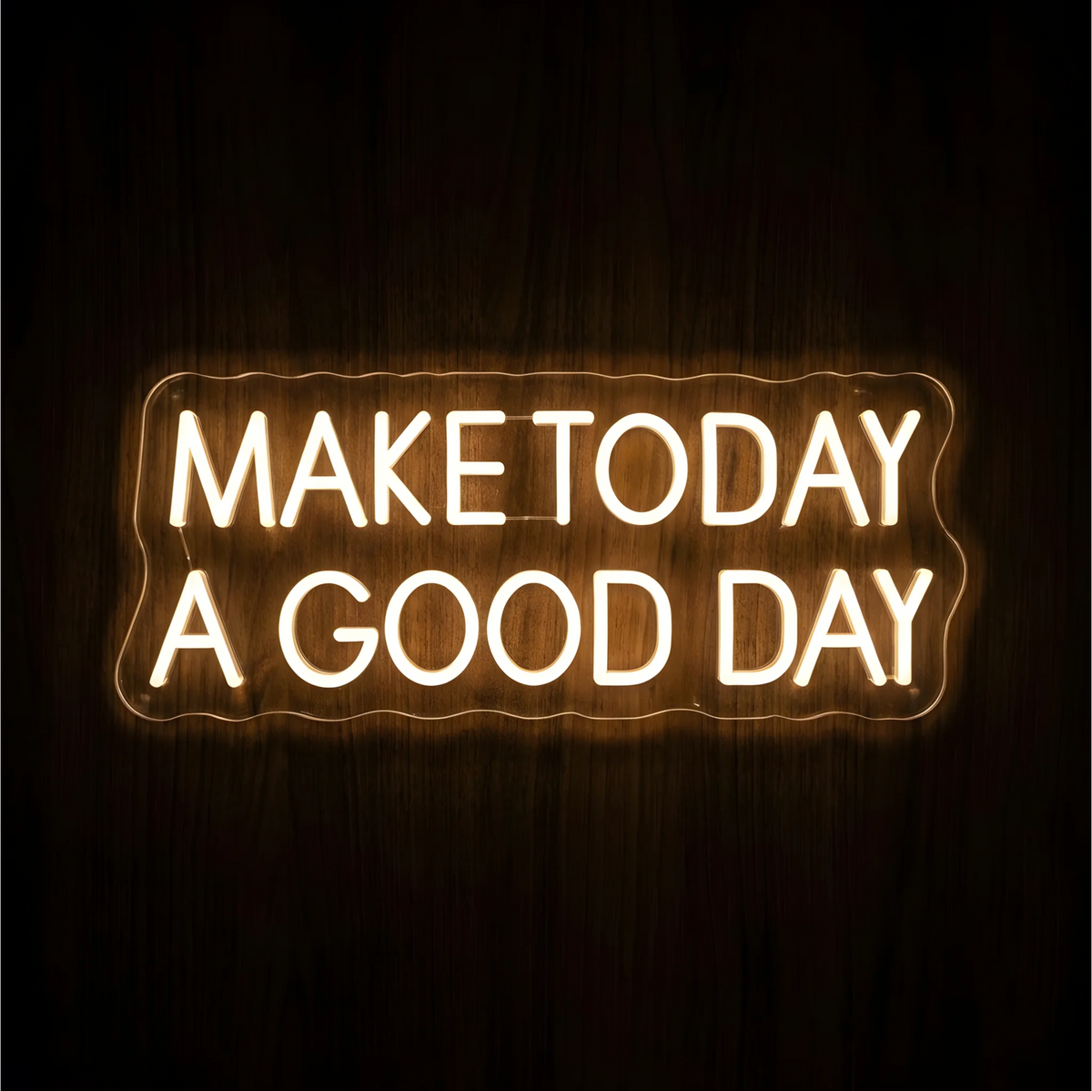 Make Today a Good Day LED Neon Sign with warm white uppercase lettering on clear acrylic against a dark wood background, suited to bedrooms and home offices.