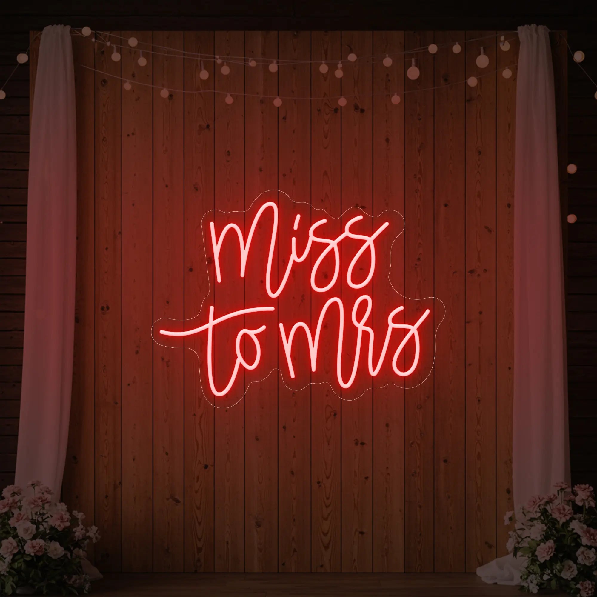 Photo of the 'Miss to Mrs' neon sign glowing in red against a styled interior wall.
