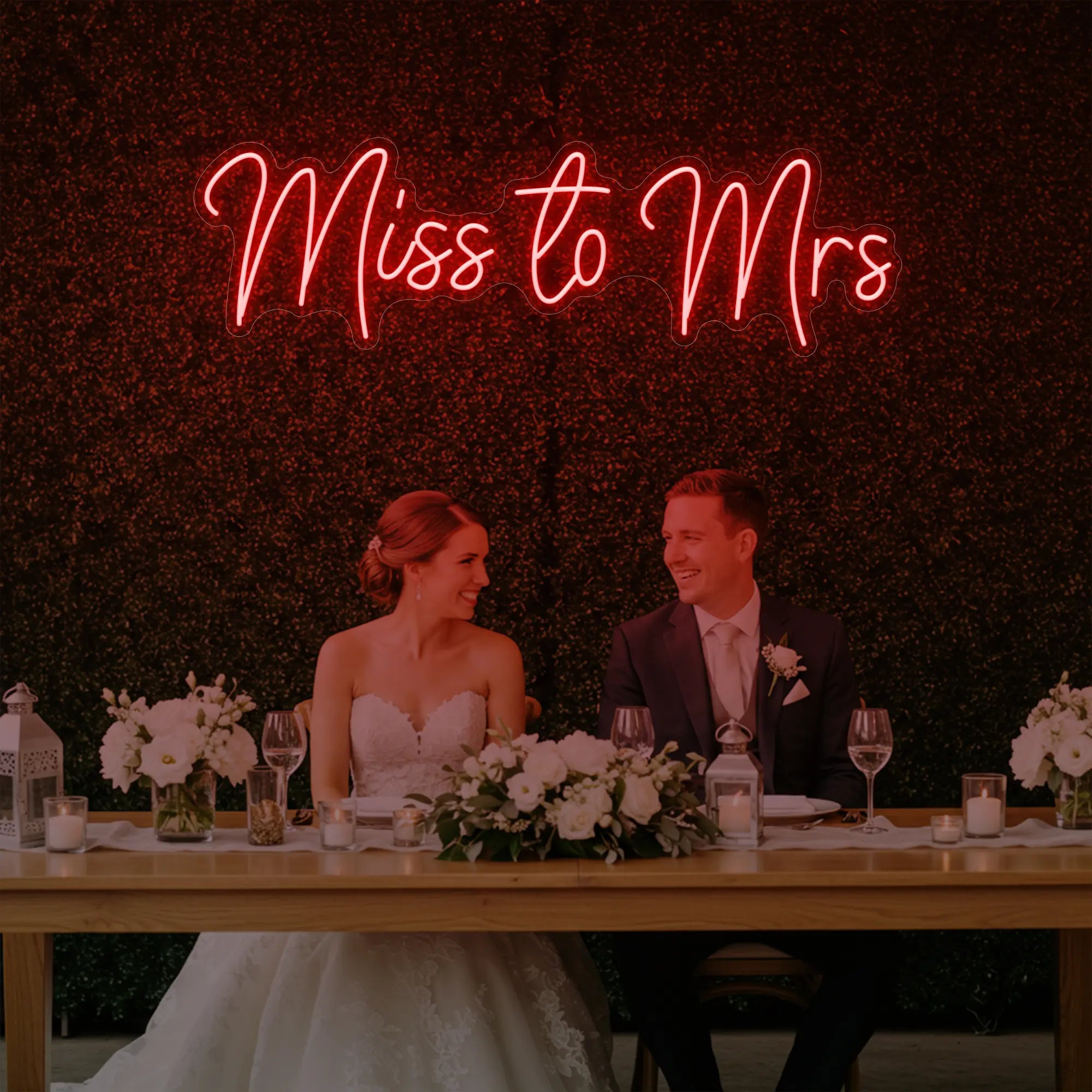 Photo of the 'Miss to Mrs' neon sign glowing in red against a styled interior wall.