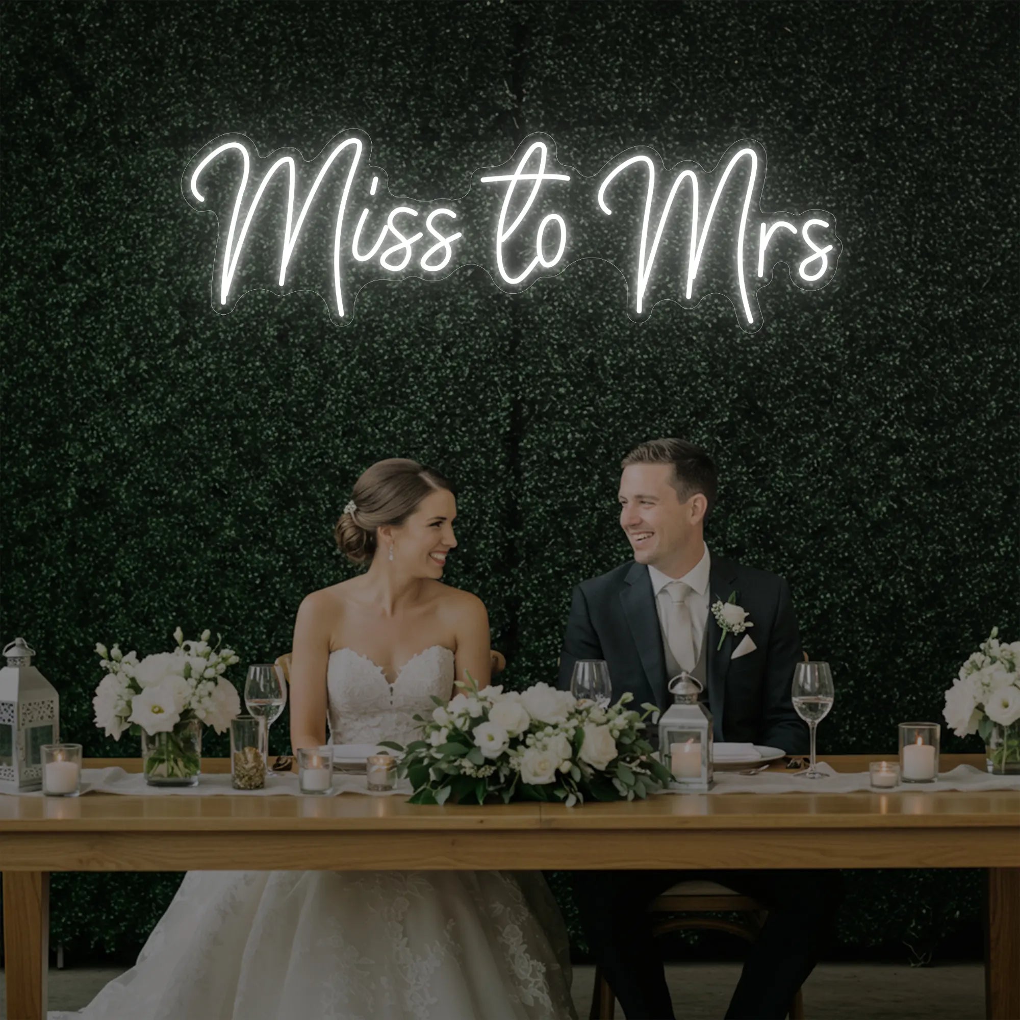 Photo of the 'Miss to Mrs' neon sign glowing in cool white against a styled interior wall.