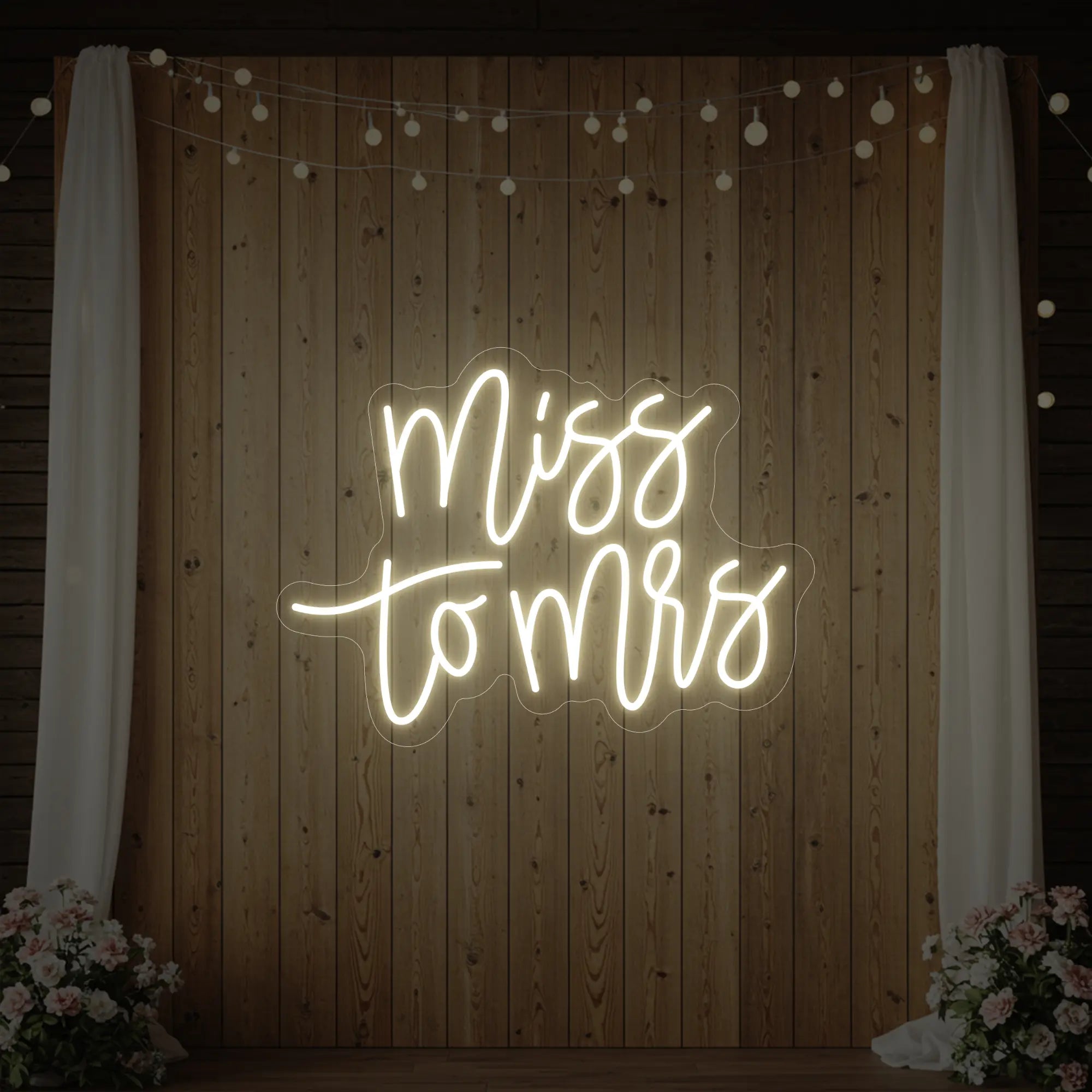 Photo of the 'Miss to Mrs' neon sign glowing in warm white against a styled interior wall.