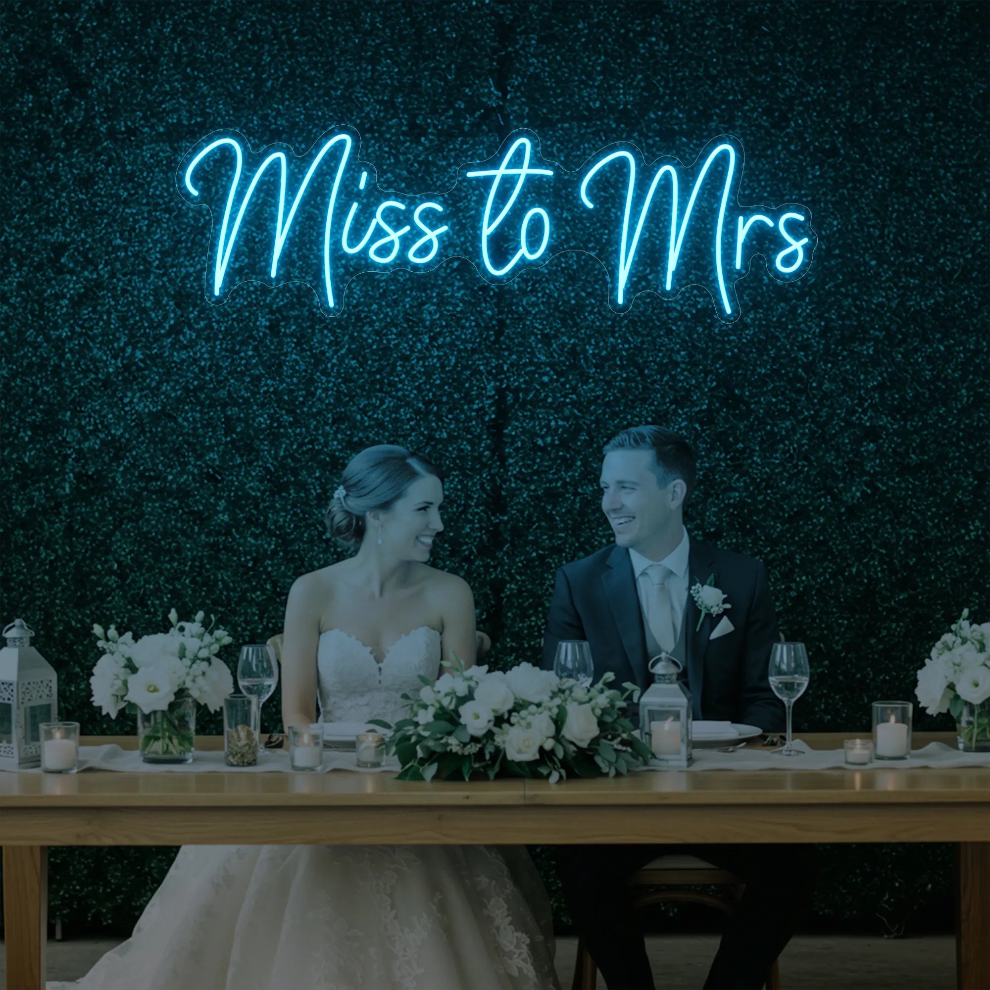 Photo of the 'Miss to Mrs' neon sign glowing in ice blue against a styled interior wall.