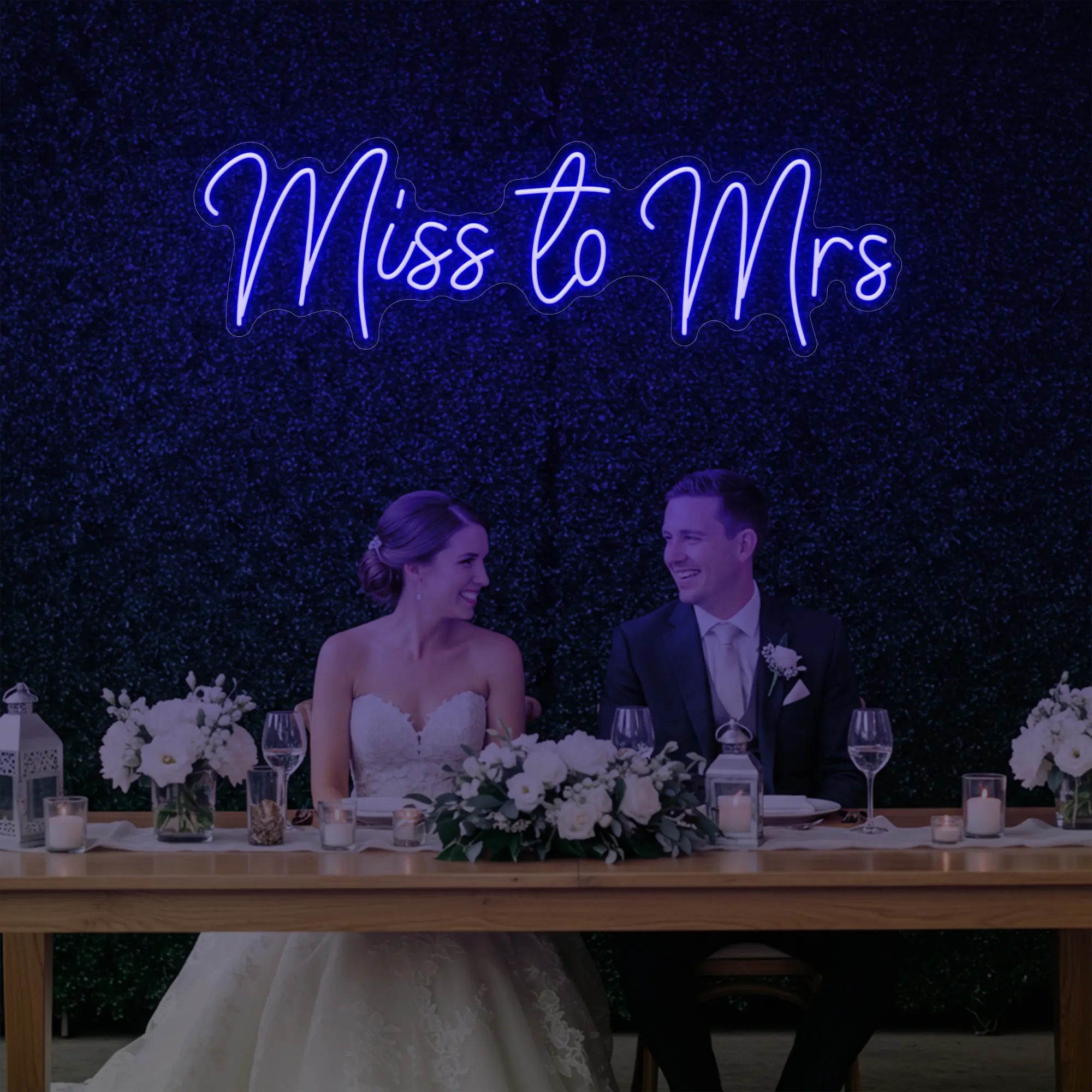 Photo of the 'Miss to Mrs' neon sign glowing in deep blue against a styled interior wall.