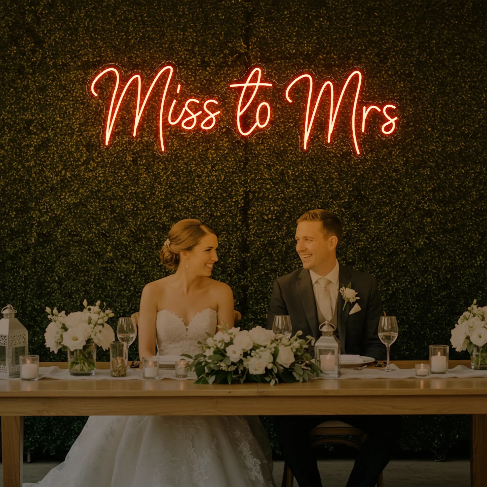Photo of the 'Miss to Mrs' neon sign glowing in golden yellow against a styled interior wall.