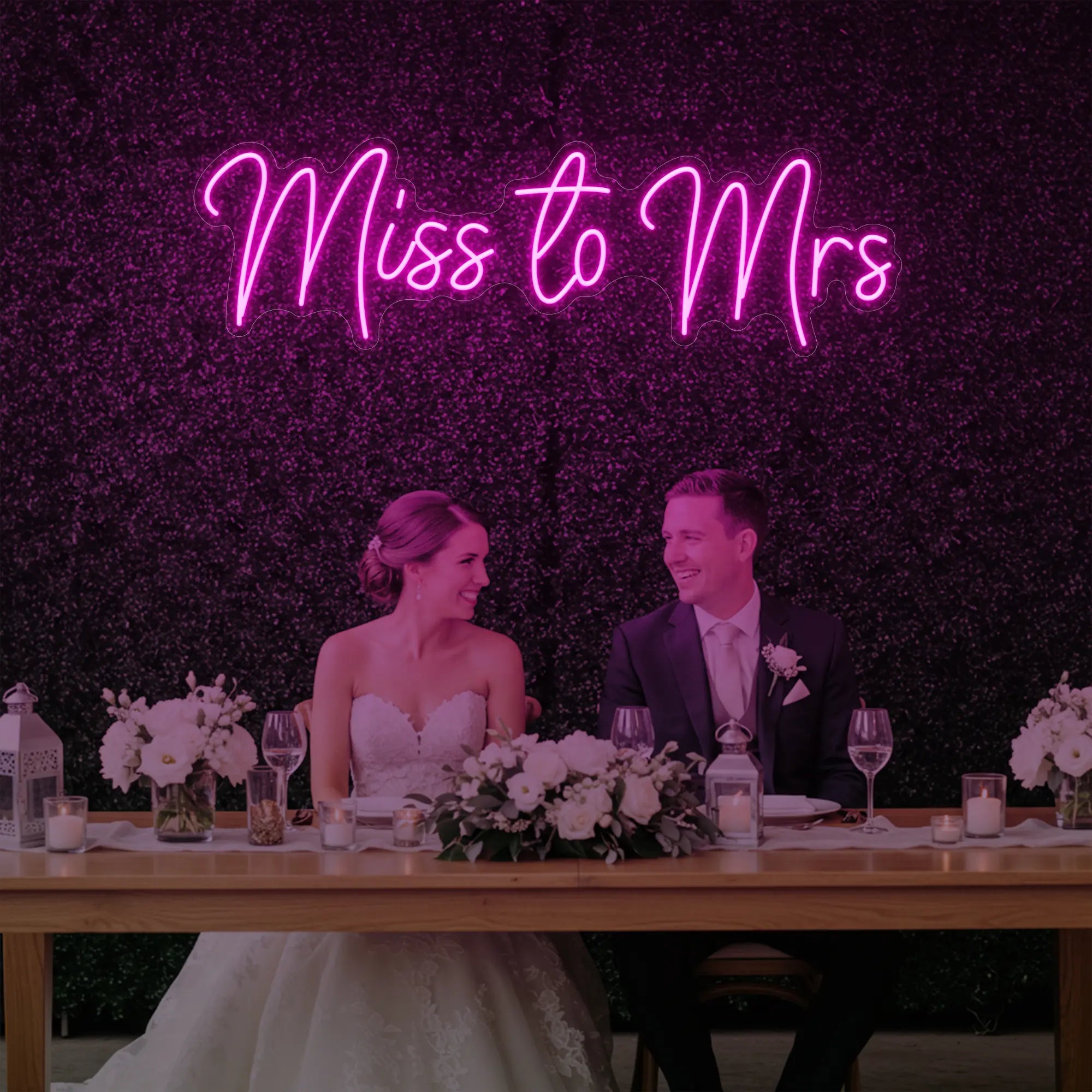 Photo of the 'Miss to Mrs' neon sign glowing in light pink against a styled interior wall.