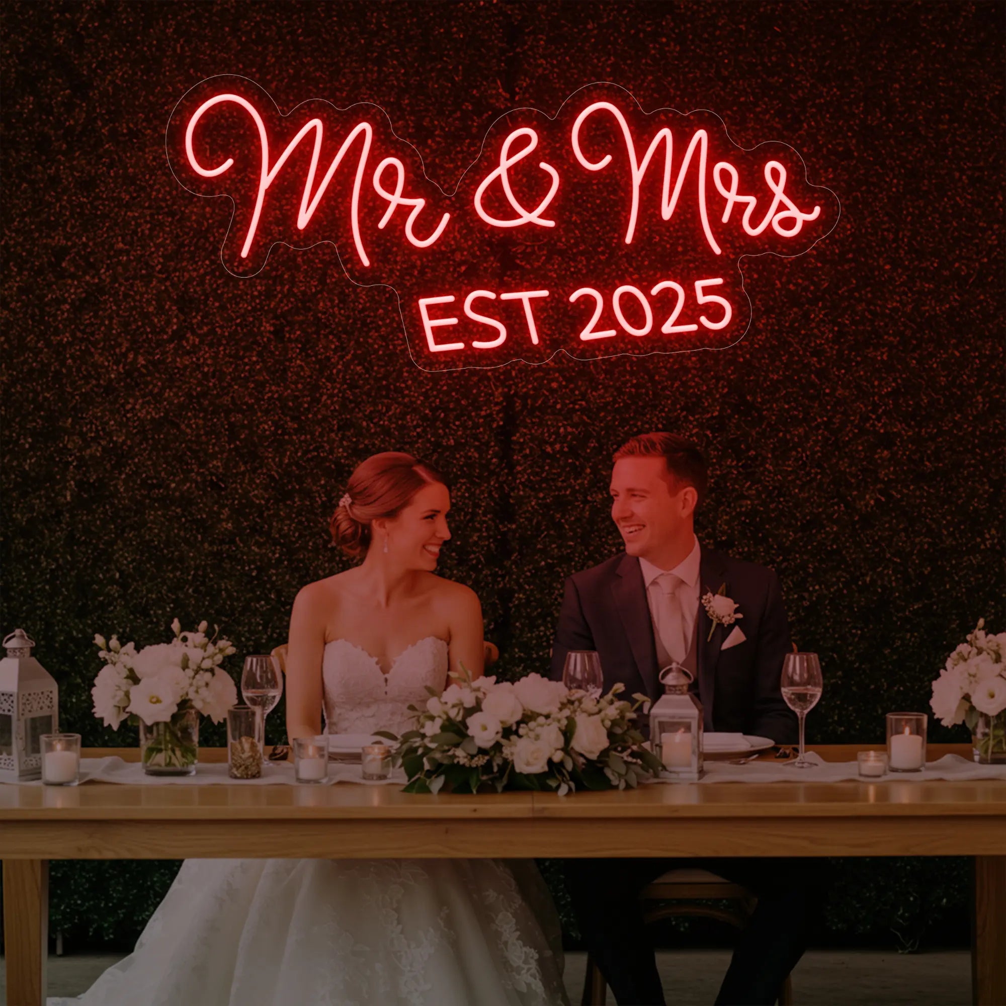 Photo of the 'Mr & Mrs EST' neon sign glowing in red against a styled interior wall.