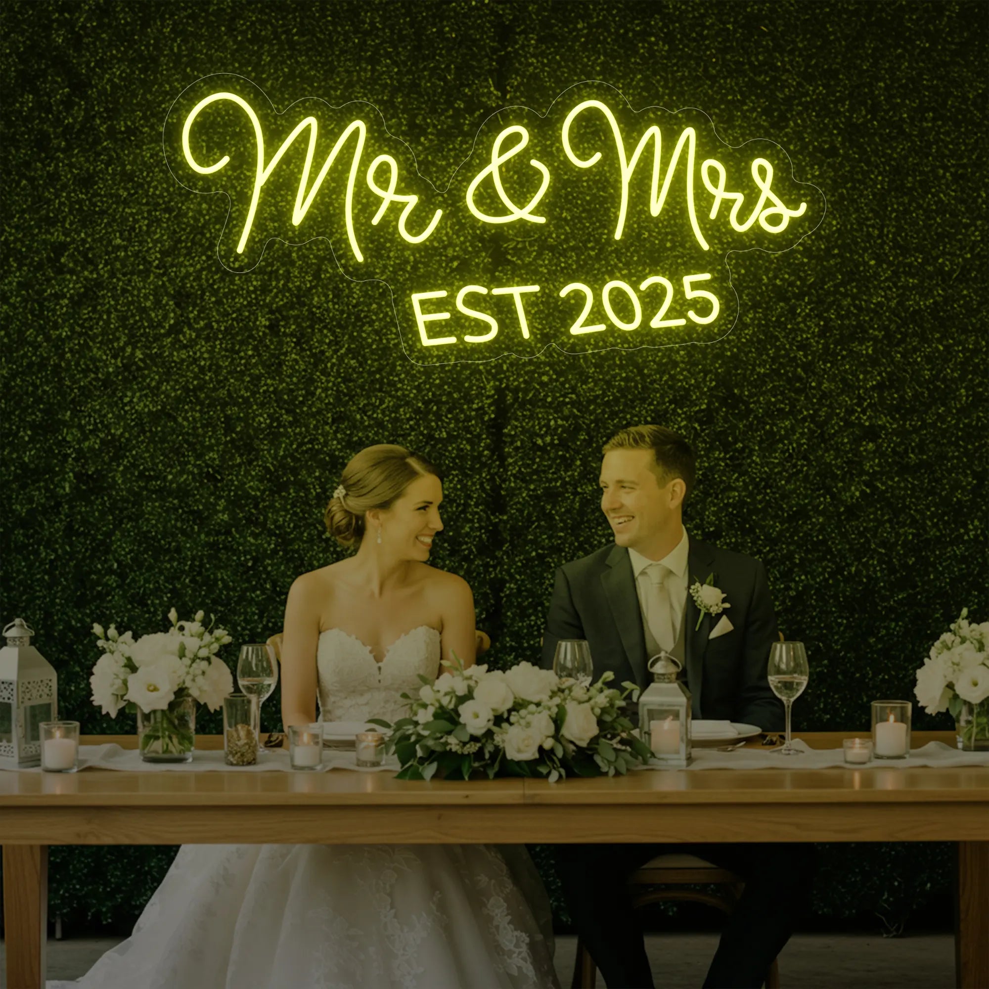Photo of the 'Mr & Mrs EST' neon sign glowing in lemon yellow against a styled interior wall.