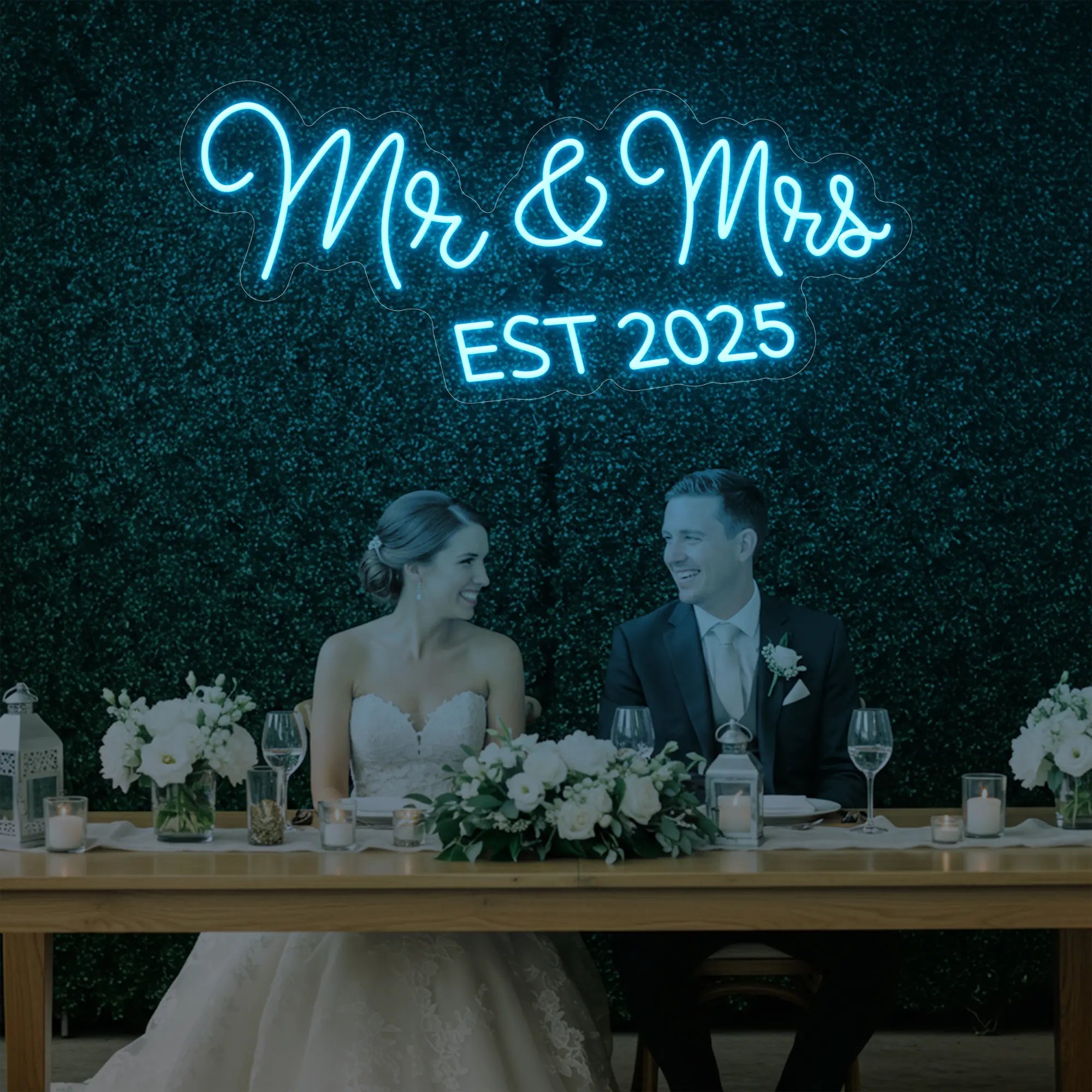 Photo of the 'Mr & Mrs EST' neon sign glowing in ice blue against a styled interior wall.