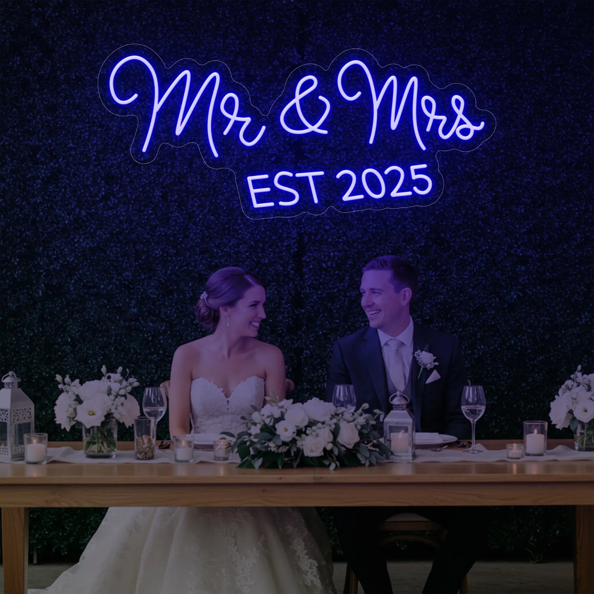 Photo of the 'Mr & Mrs EST' neon sign glowing in deep blue against a styled interior wall.