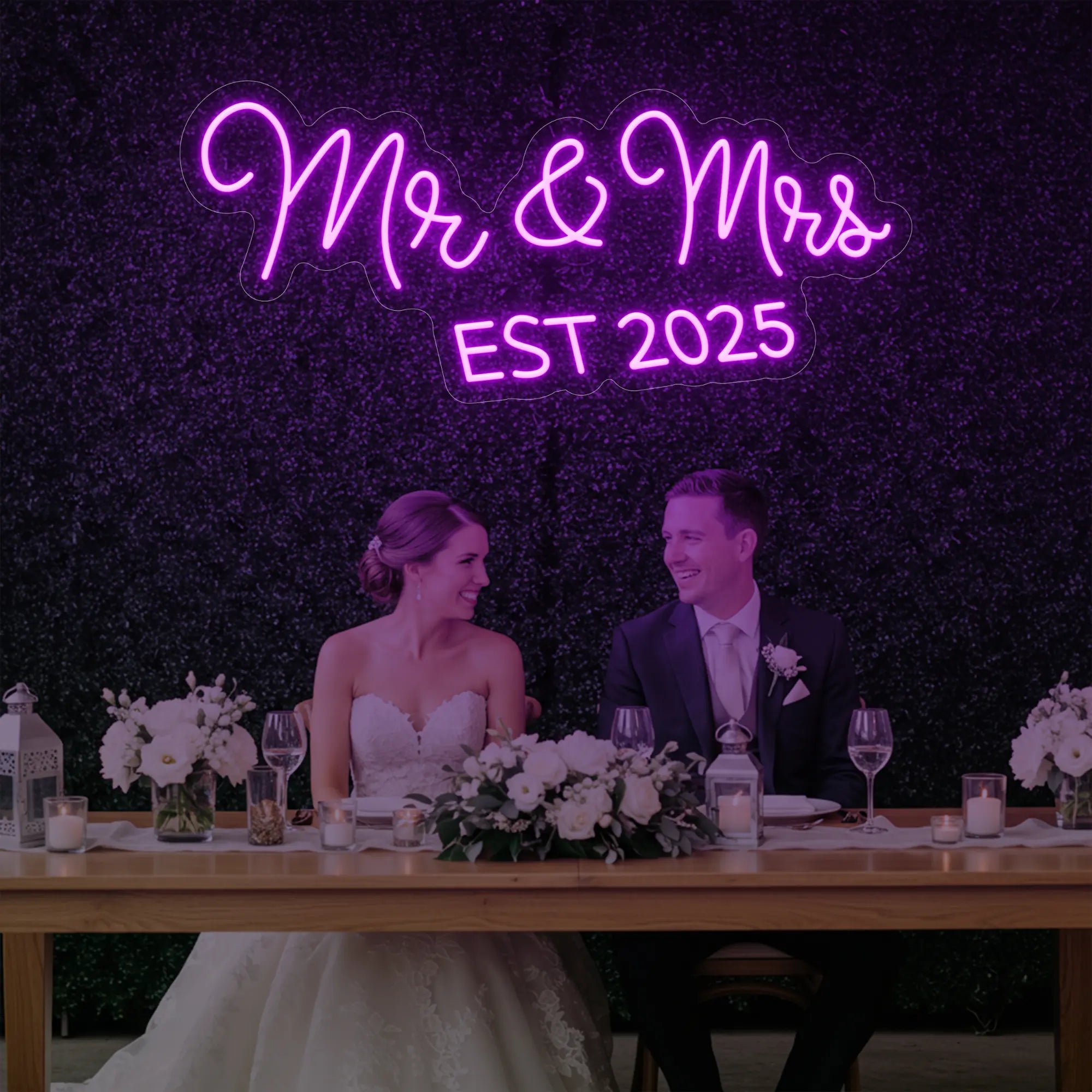 Photo of the 'Mr & Mrs EST' neon sign glowing in deep pink against a styled interior wall.