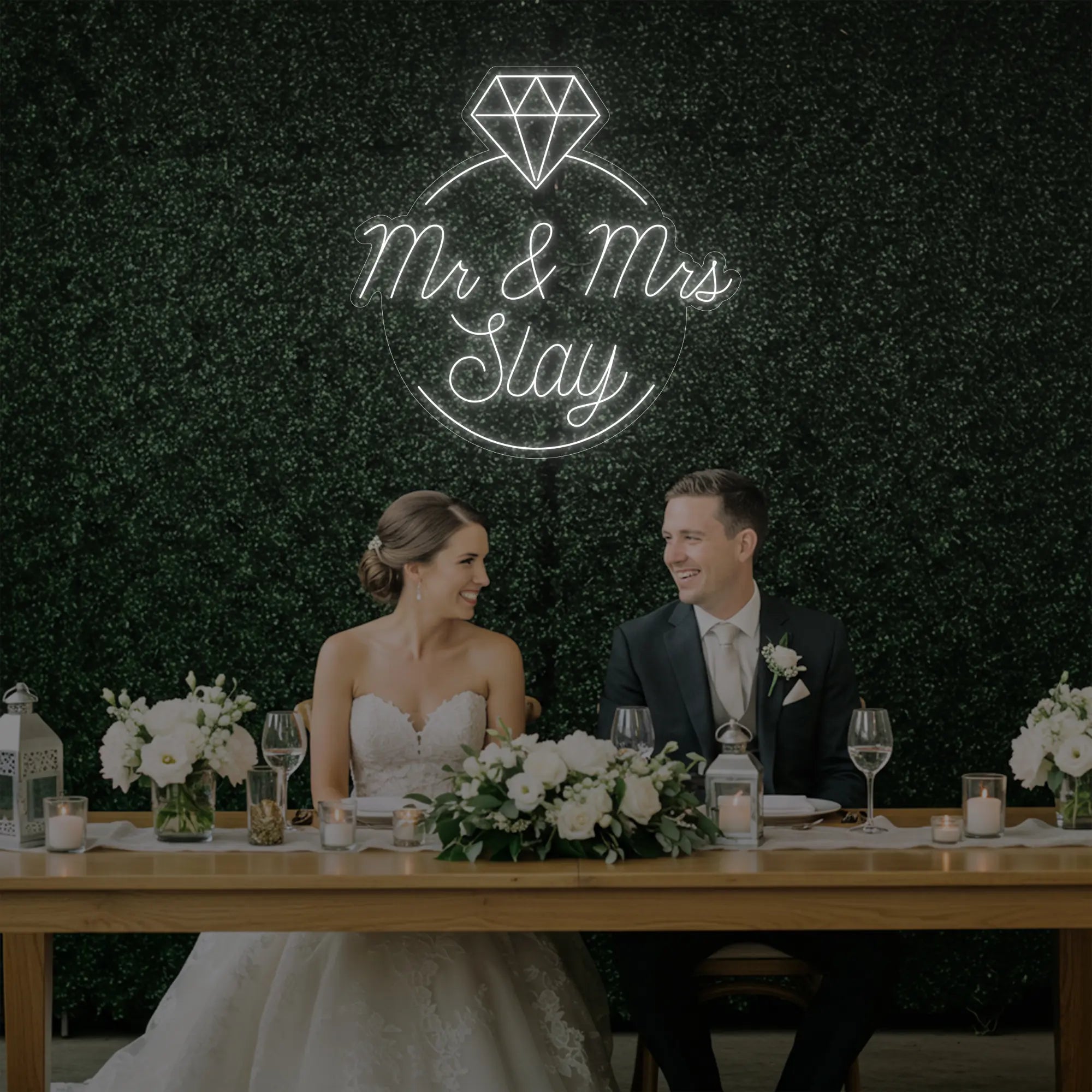 Photo of the 'Mr & Mrs EST' neon sign glowing in cool white against a styled interior wall.