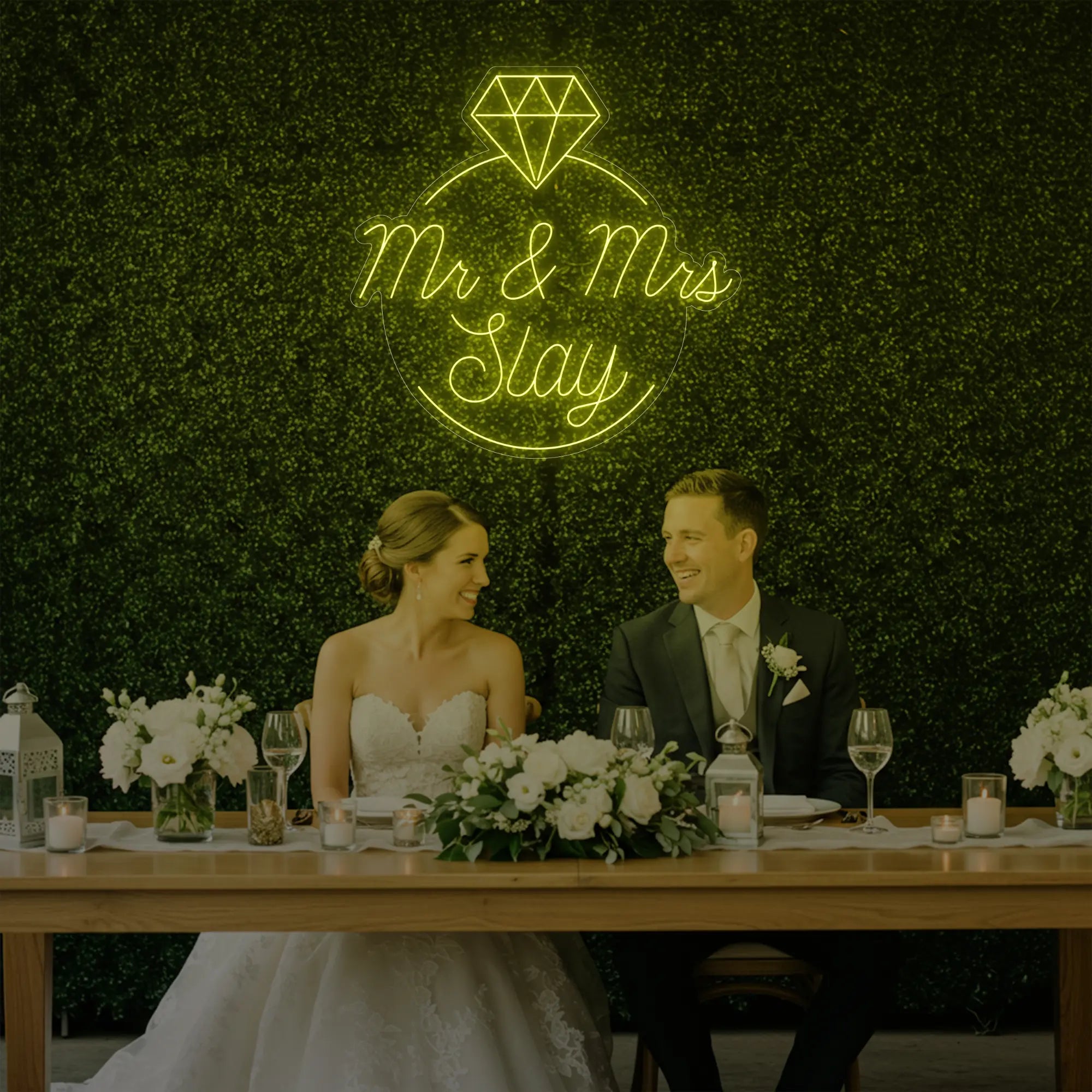 Photo of the 'Mr & Mrs EST' neon sign glowing in lemon yellow against a styled interior wall.