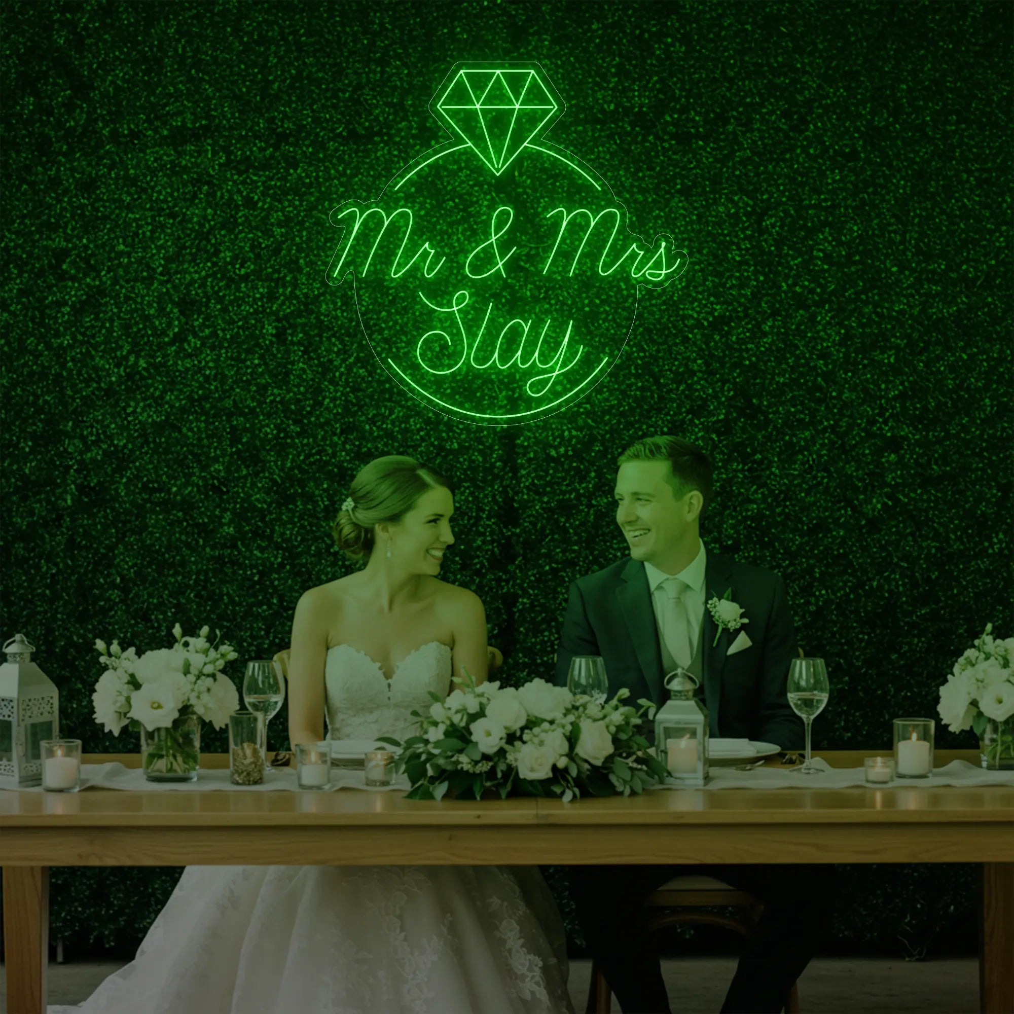 Photo of the 'Mr & Mrs EST' neon sign glowing in green against a styled interior wall.