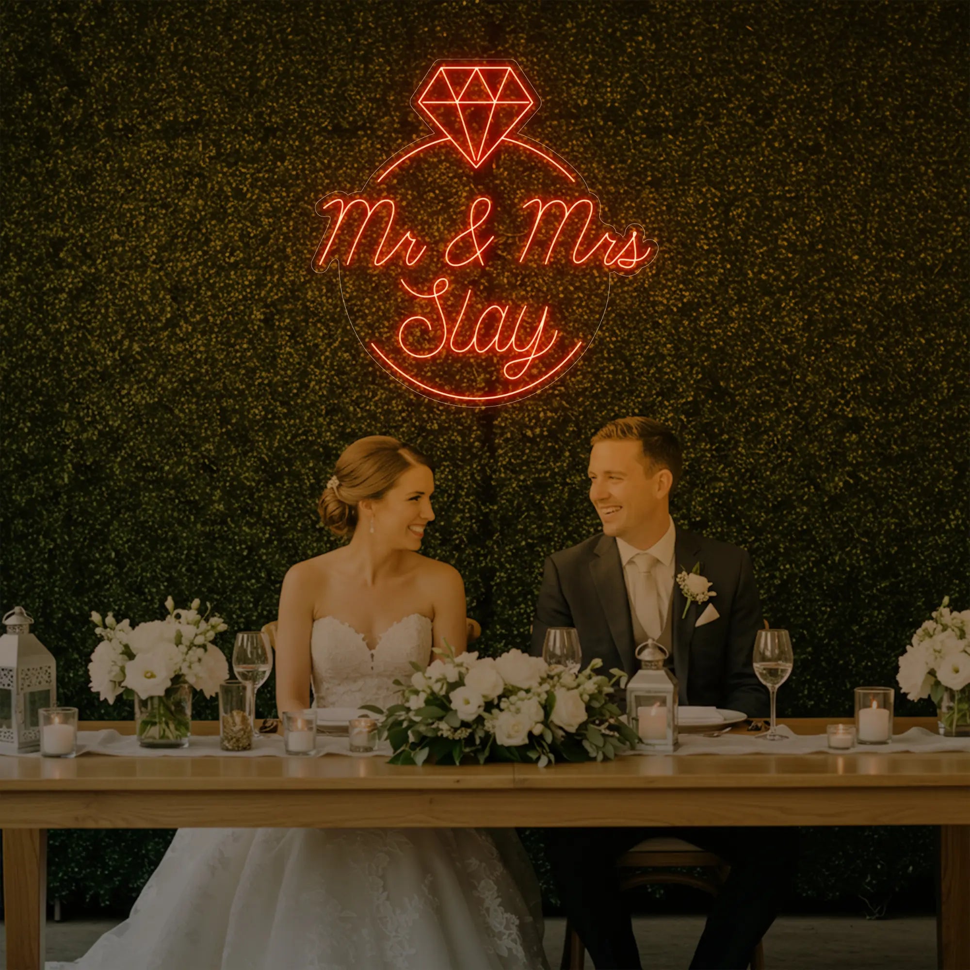 Photo of the 'Mr & Mrs EST' neon sign glowing in golden yellow against a styled interior wall.