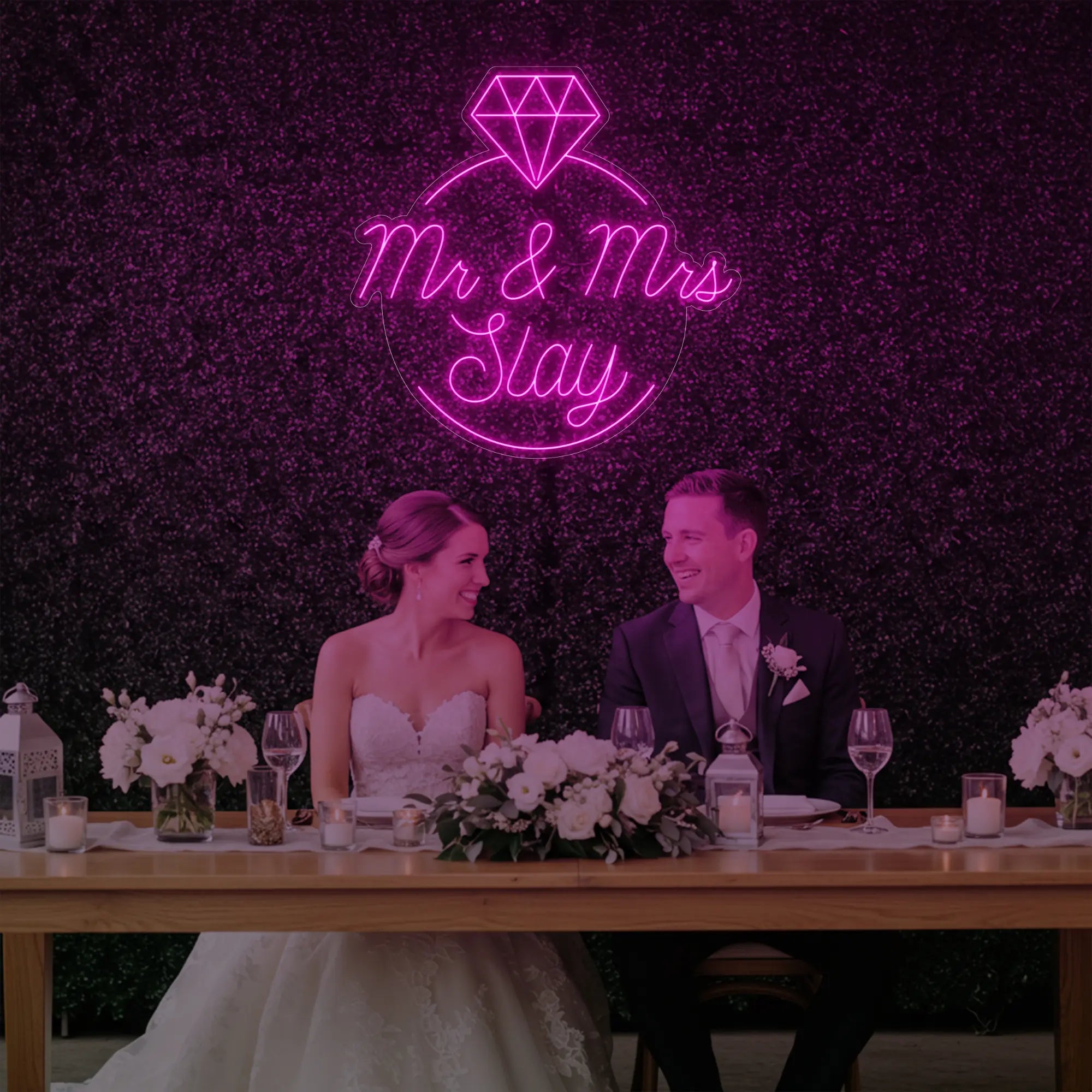 Photo of the 'Mr & Mrs EST' neon sign glowing in light pink against a styled interior wall.