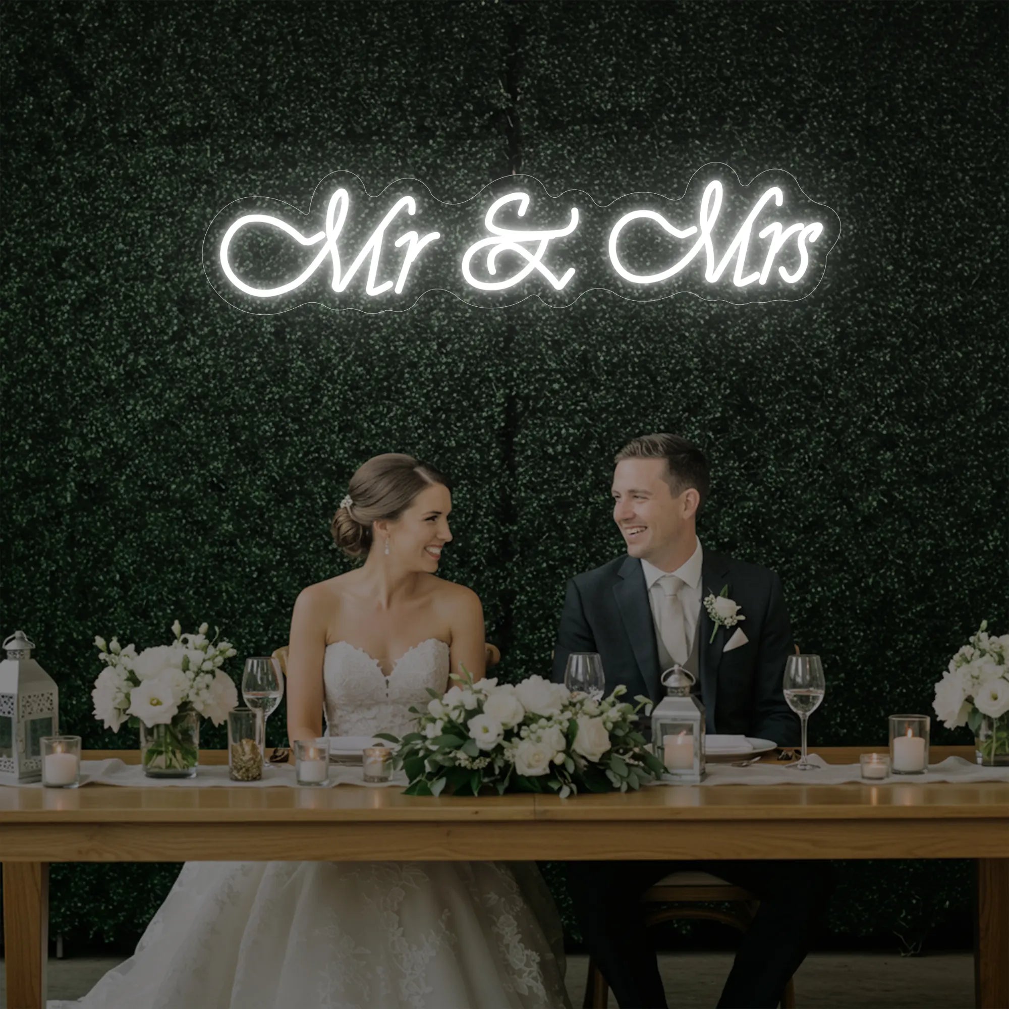 Photo of the 'Mr & Mrs' neon sign glowing in cool white against a styled interior wall.