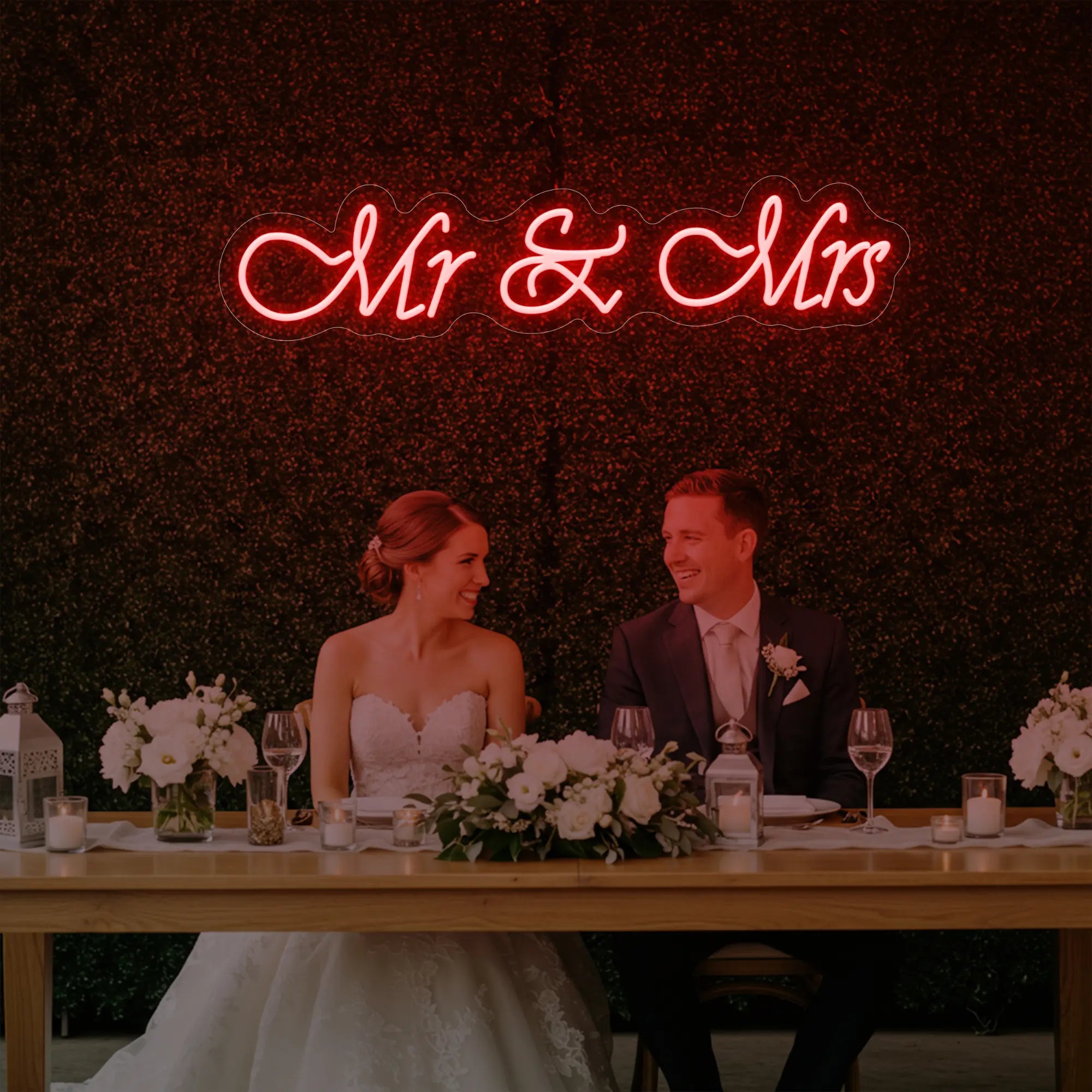 Photo of the 'Mr & Mrs' neon sign glowing in red against a styled interior wall.