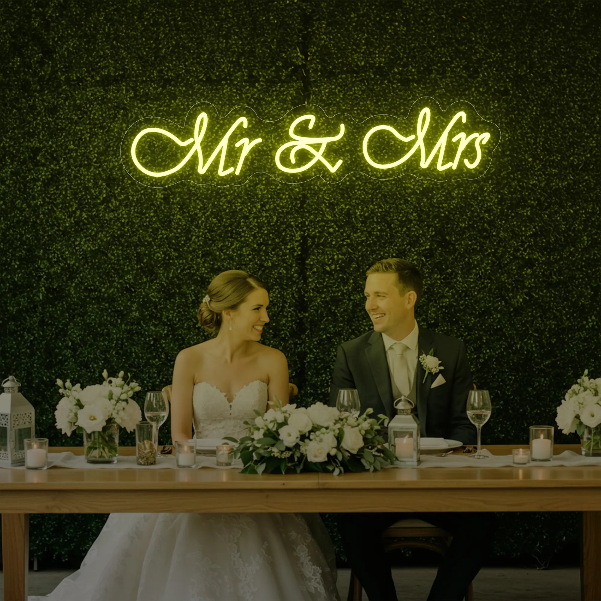Photo of the 'Mr & Mrs' neon sign glowing in lemon yellow against a styled interior wall.