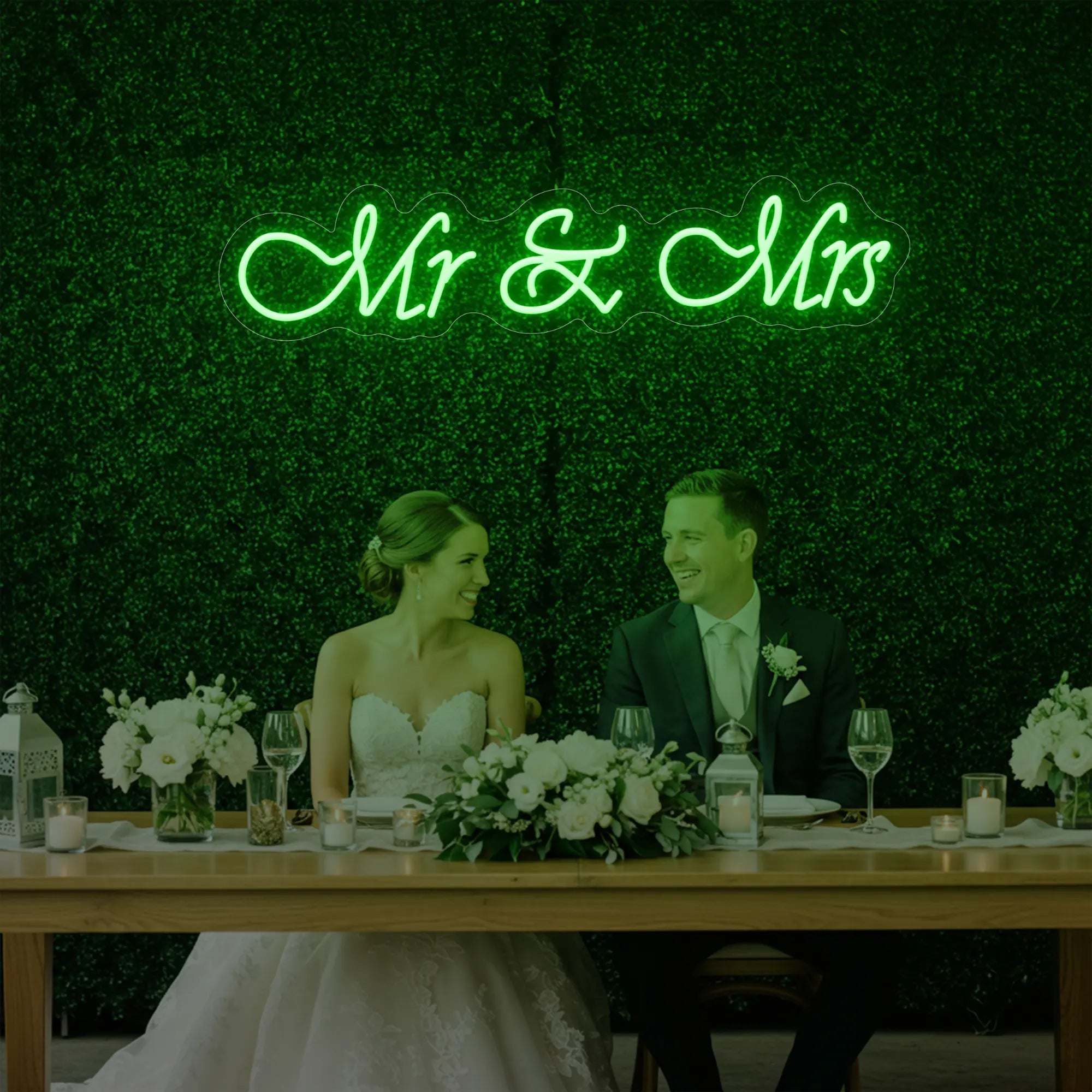 Photo of the 'Mr & Mrs' neon sign glowing in green against a styled interior wall.