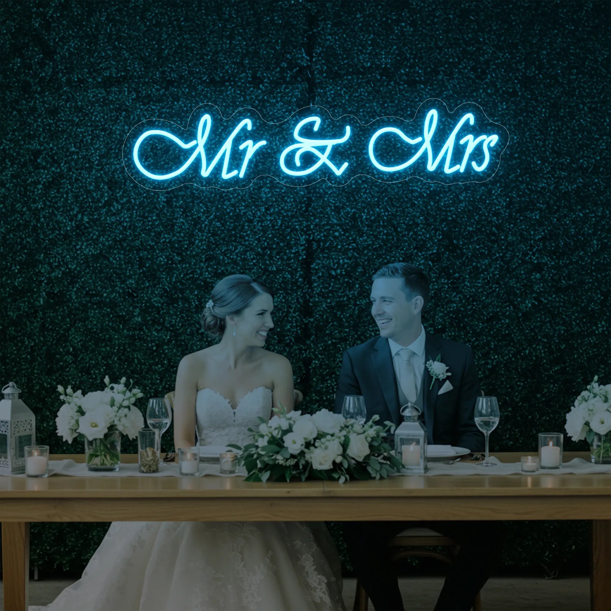 Photo of the 'Mr & Mrs' neon sign glowing in ice blue against a styled interior wall.