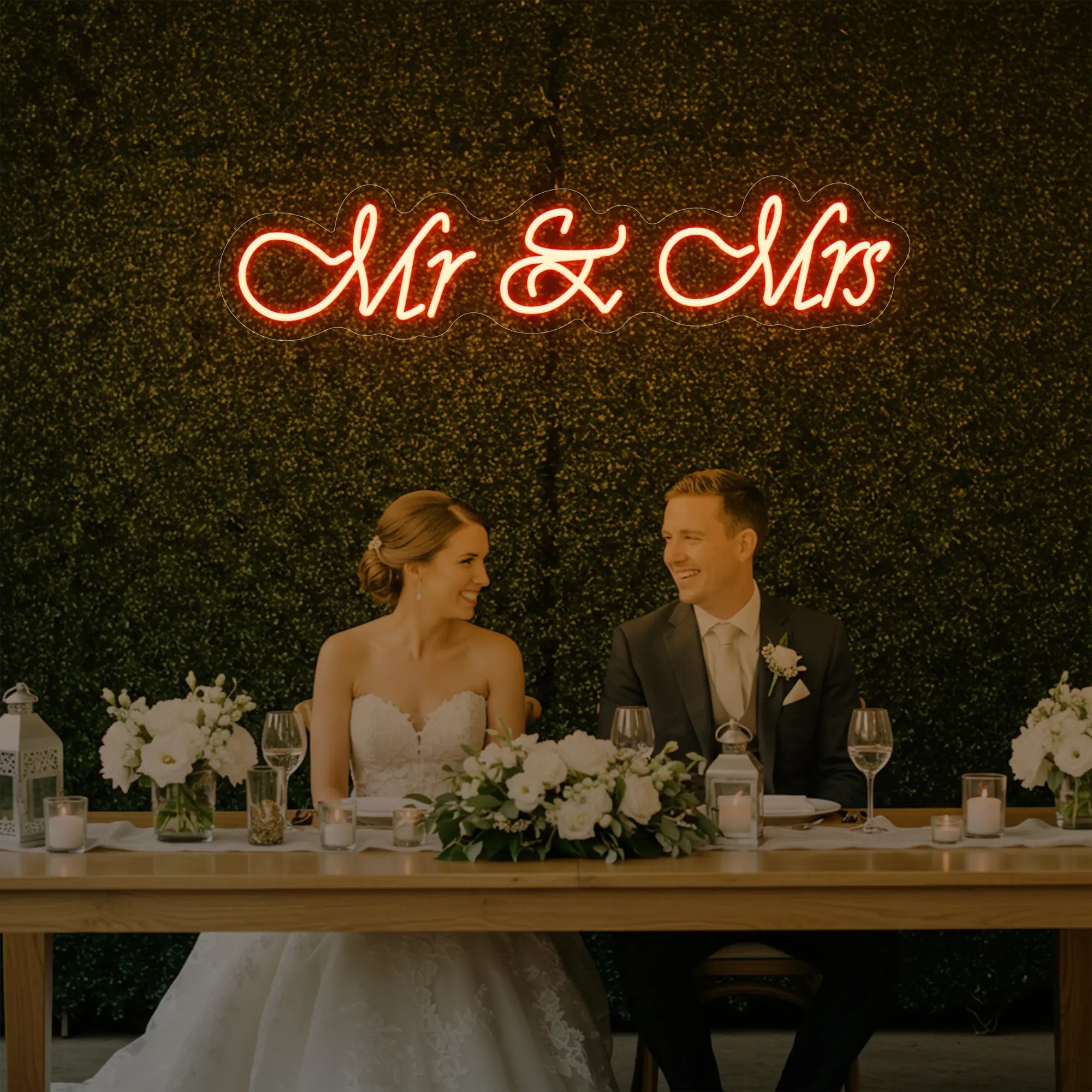 Photo of the 'Mr & Mrs' neon sign glowing in golden yellow against a styled interior wall.