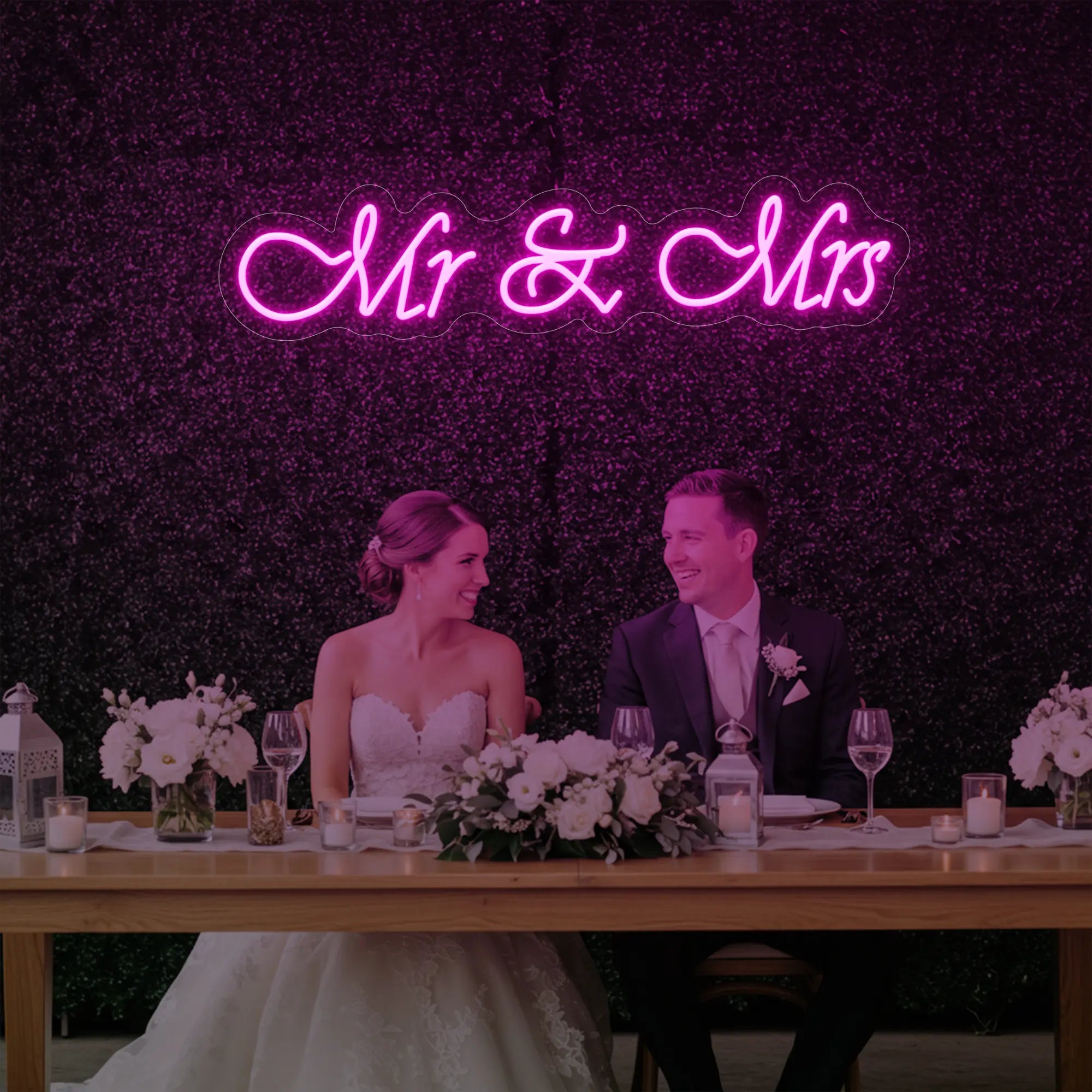 Photo of the 'Mr & Mrs' neon sign glowing in light pink against a styled interior wall.