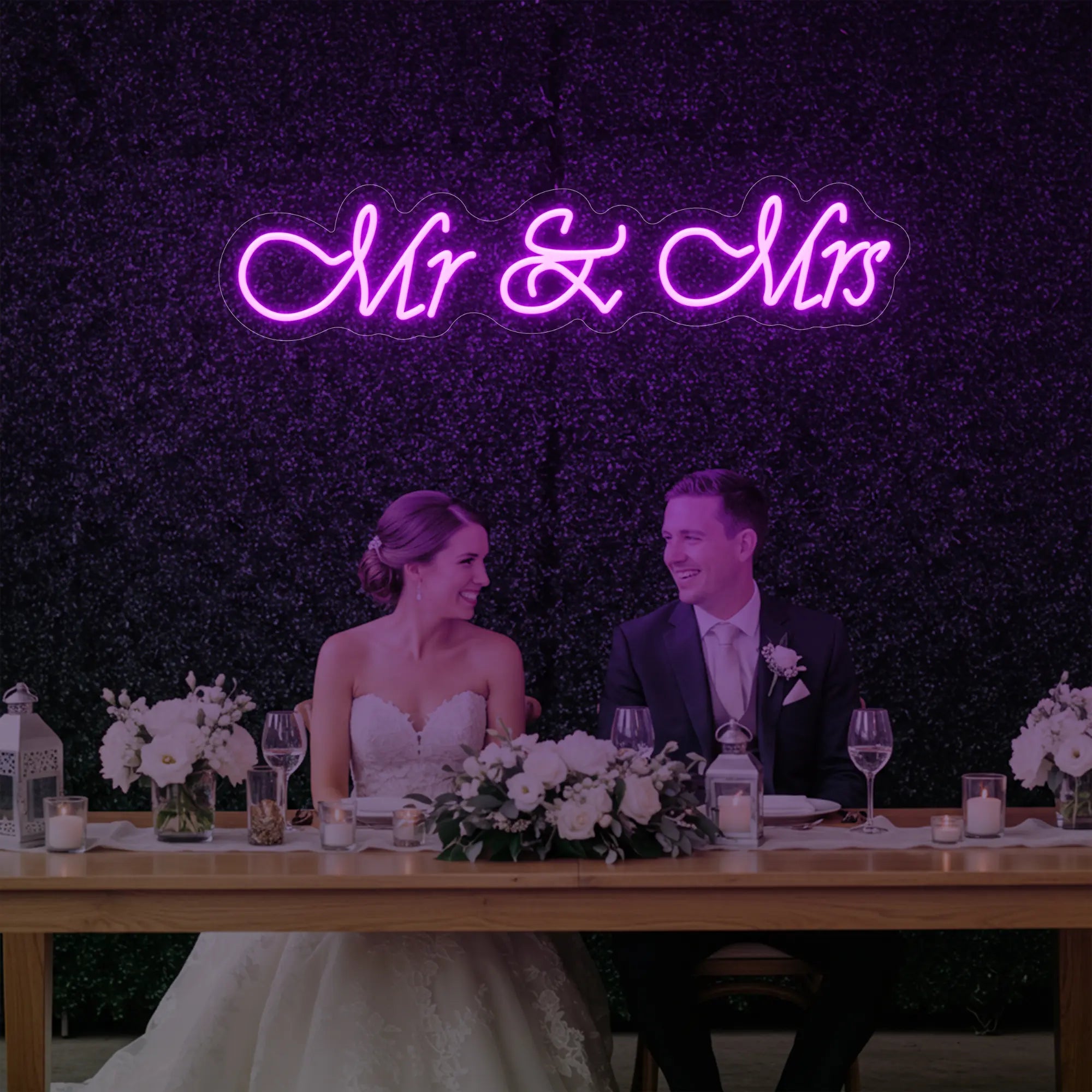 Photo of the 'Mr & Mrs' neon sign glowing in deep pink against a styled interior wall.