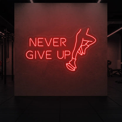 'NEVER GIVE UP' neon sign glowing in red against a styled interior wall.