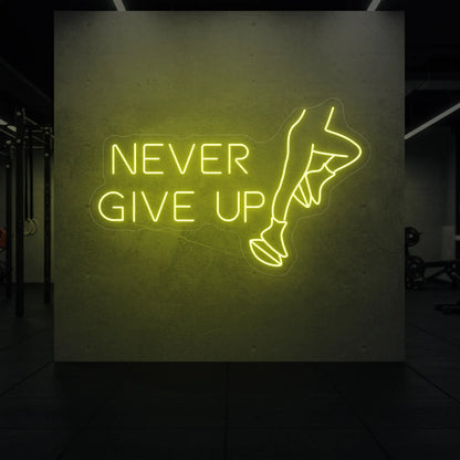  'NEVER GIVE UP' neon sign glowing in lemon yellow against a styled interior wall.