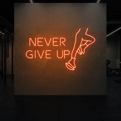  'NEVER GIVE UP' neon sign glowing in golden yellow against a styled interior wall.