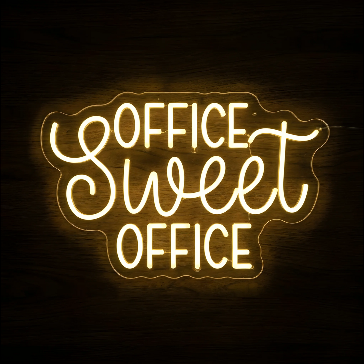 Office Sweet Office LED Neon Sign glowing warm yellow, with uppercase “OFFICE” lettering and script “Sweet” on clear acrylic against a dark wood background, suitable for home offices and workspaces.