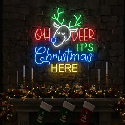 Photo of the 'Oh Deer It's Christmas Here' neon sign glowing in cool white against a styled interior wall.