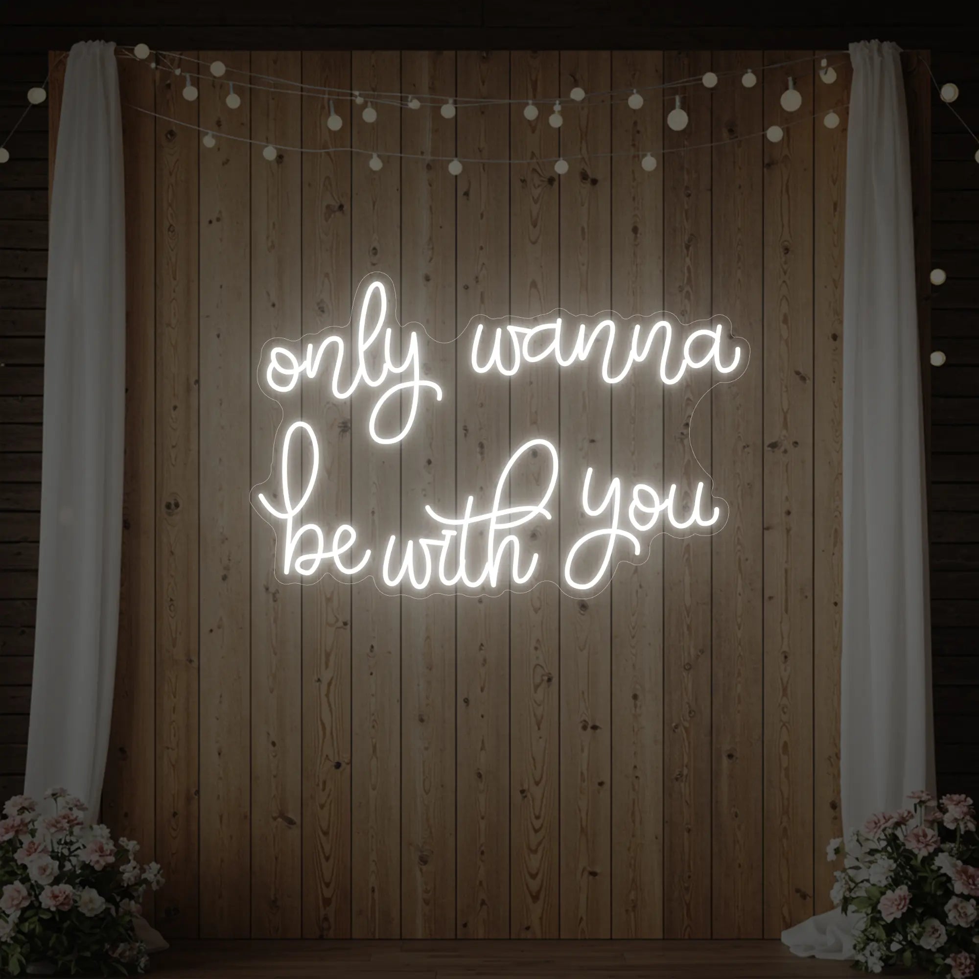 Photo of the 'Only Wanna Be With You' neon sign glowing in cool white against a styled interior wall.