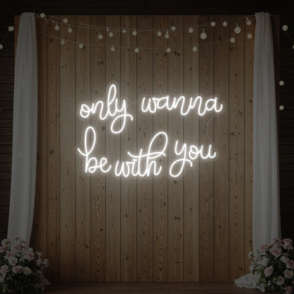 Photo of the 'Only Wanna Be With You' neon sign glowing in cool white against a styled interior wall.