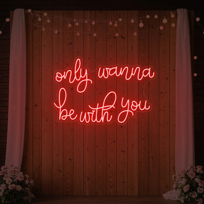 Photo of the 'Only Wanna Be With You' neon sign glowing in red against a styled interior wall.
