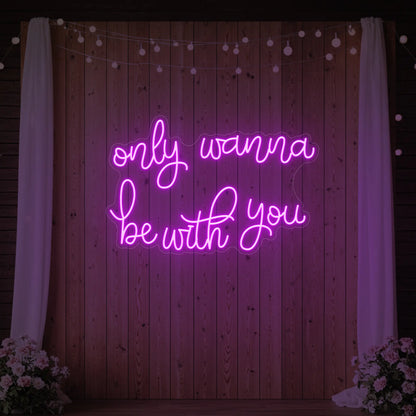 Photo of the 'Only Wanna Be With You' neon sign glowing in deep pink against a styled interior wall.