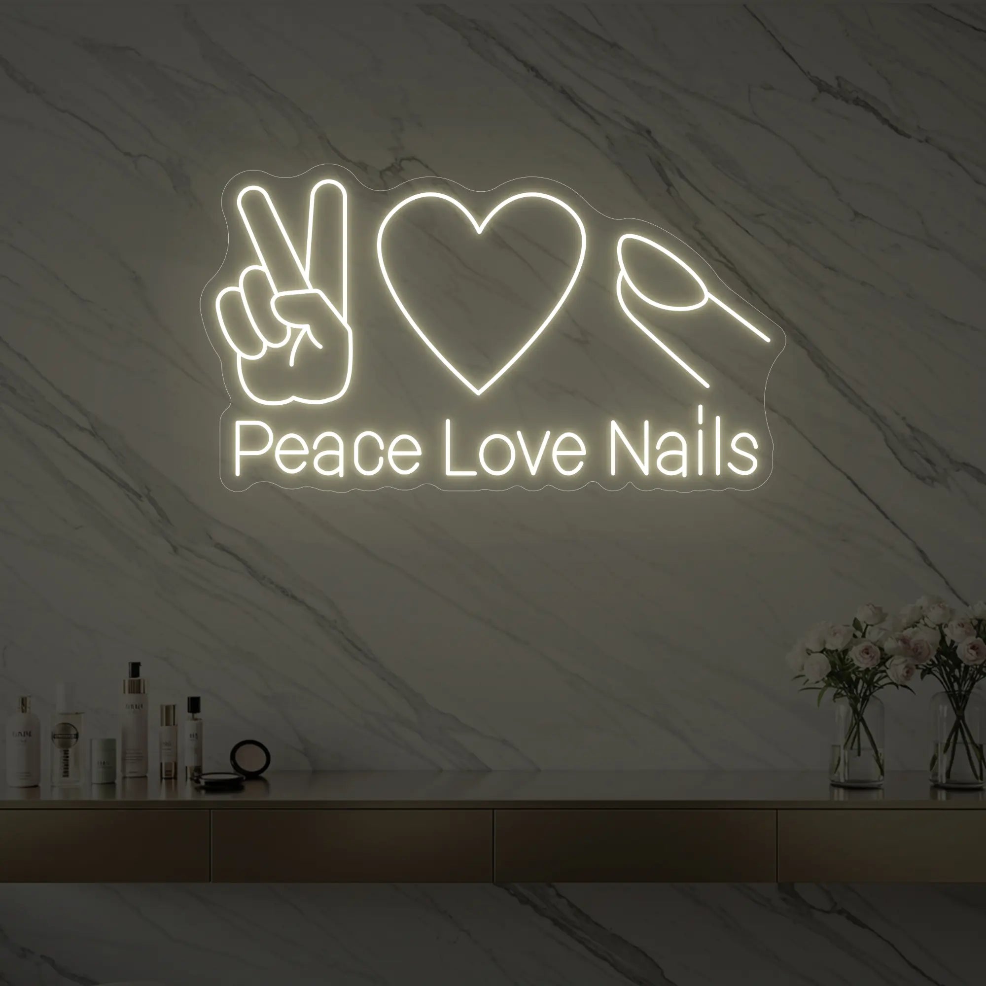Photo of the 'Peace Love Nails' neon sign glowing in warm white against a styled interior wall.
