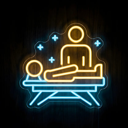 Physical Rehabilitation Therapy LED neon sign featuring a yellow therapist and patient illustration on a blue treatment table with blue medical crosses and clear acrylic backing for physiotherapy clinic wall decor.