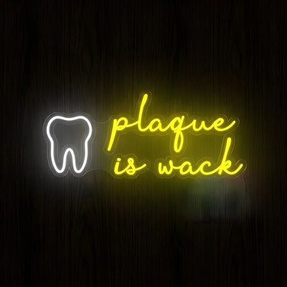 Plaque Is Wack LED neon sign featuring a cool white tooth outline beside bright yellow plaque is wack cursive lettering on clear acrylic backing for dental clinic wall decor.